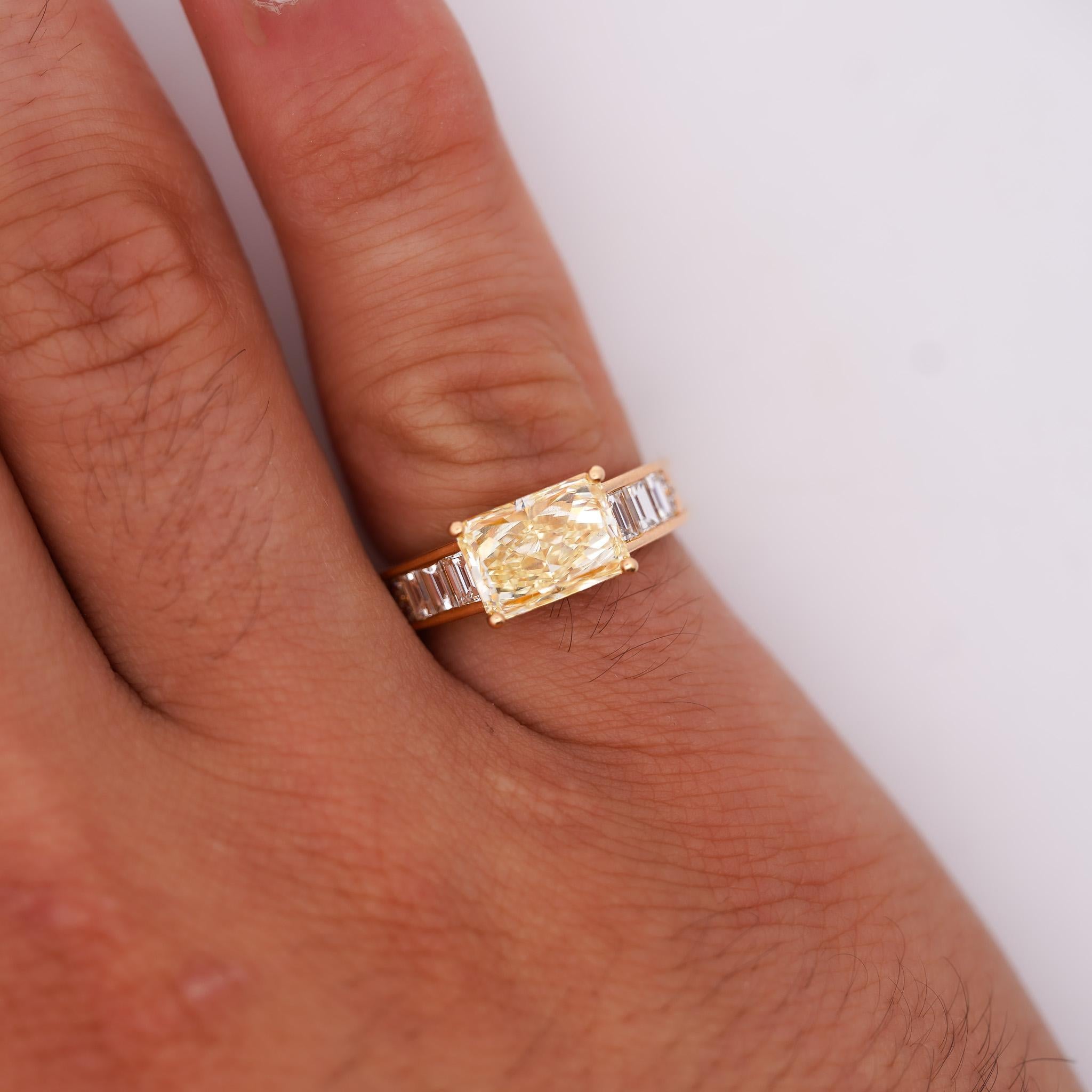 Bague en or jaune 18 carats, certifiée GIA, ornée d'un diamant jaune de taille radiant de 3,04 carats en serti est-ouest et de 0,82 carats de diamants baguettes. Taille 7, réglable, pèse 5,78 grammes avec une monture à quatre