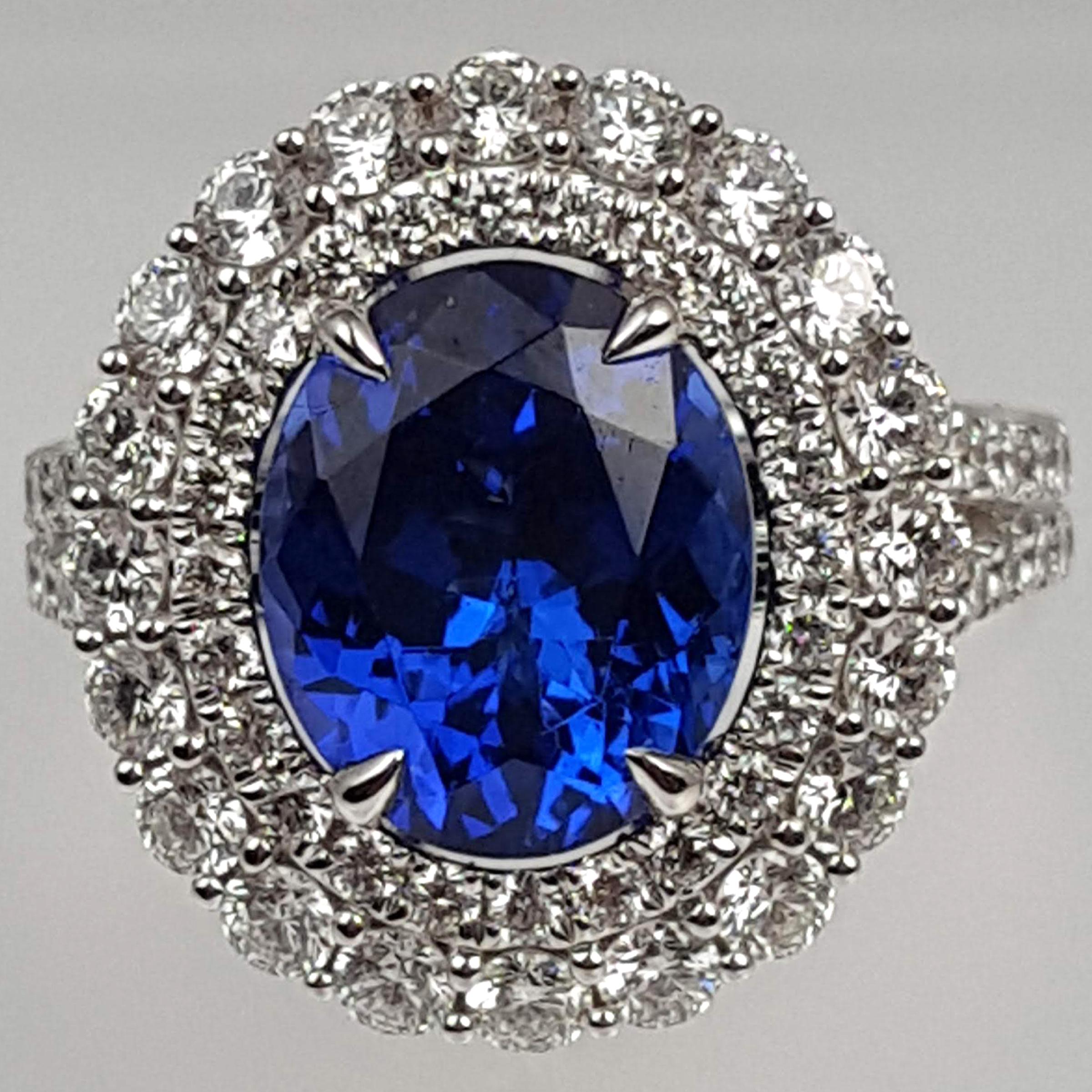 Featuring a GIA Certified 3.97 carat oval-cut tanzanite center and enveloped by a double halo of 1.89 carats of white diamonds, this ring radiates brilliance from every perspective. The intricate hand-engraved milgrain work throughout the piece