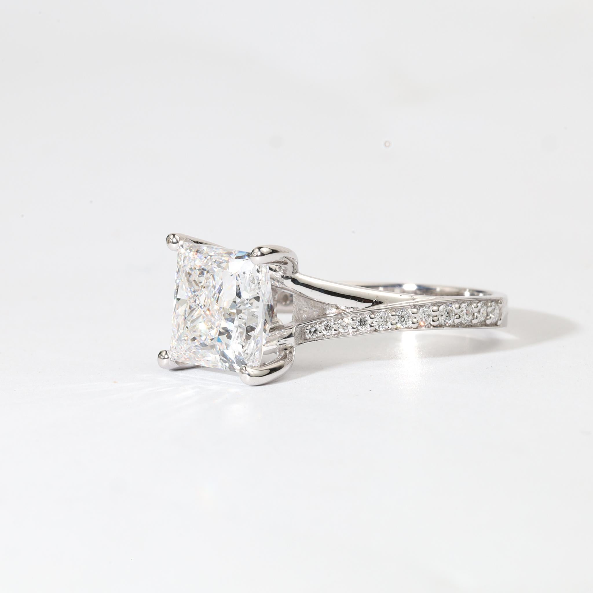 Moderne Majestät, Art-Deco-Präzision

Dieser skulpturale Kraftprotz wird von einem 3,00-Karat-Diamanten im Prinzessinnenschliff gekrönt, der GIA-zertifiziert ist und eine eisige E-Farbe mit raffinierter VS-Klarheit aufweist. Die quadratische