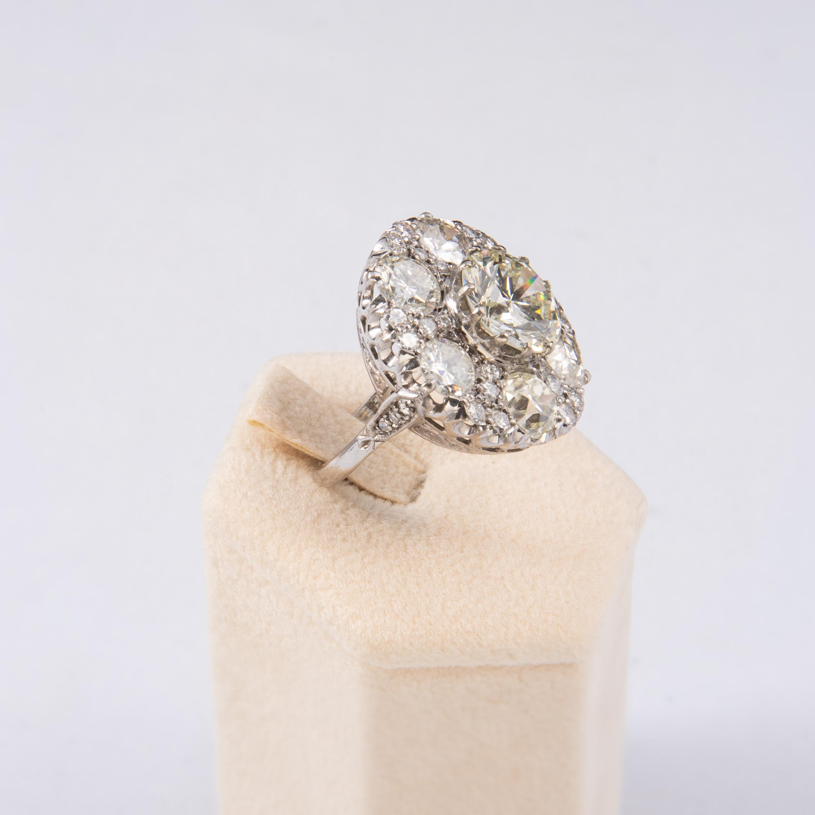 This magnificent vintage 4,04 carat diamond ring dates circa 1940s and is centered with one round brilliant cut diamond weighing 4.04 carats and set with six diamond old cut 0,80 ct each for a total 10 ct. The diamond is GIA certified L/S1 and has a