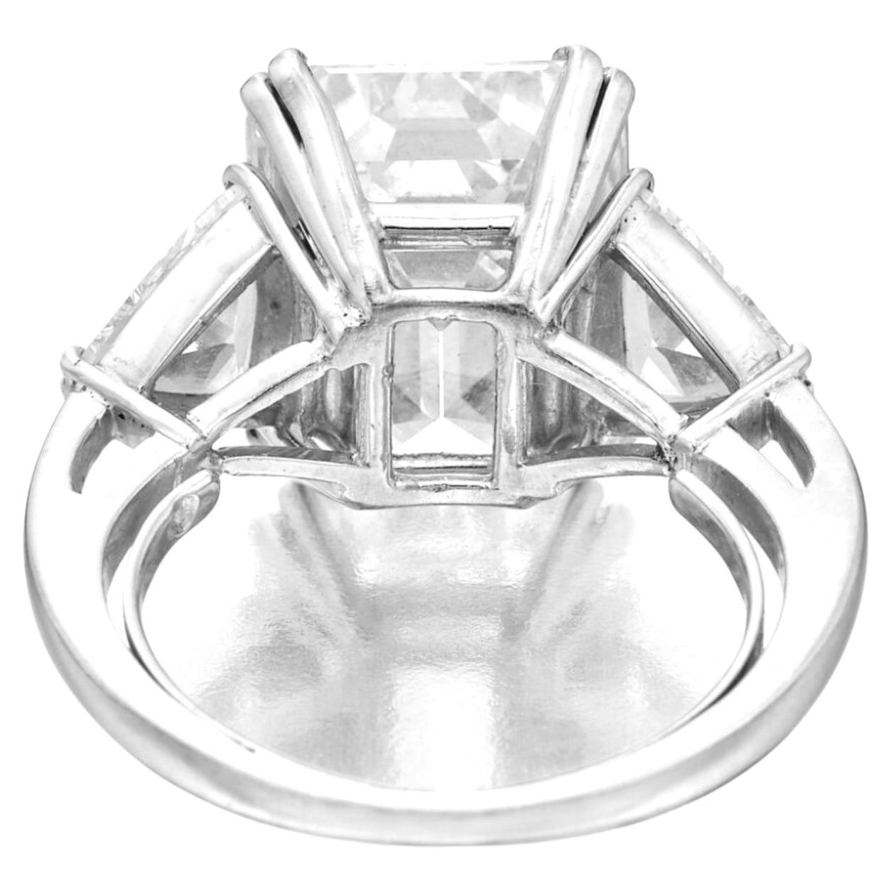 This elegant three stone engagement ring features a stunning 4.06 carat emerald cut diamond at it's center, flanked by two exquisite trillion cut diamonds. 

The central diamond, with it's color grade of 