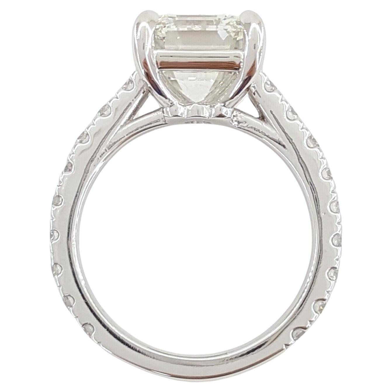 This exquisite engagement ring features a breathtaking 4.04 carat emerald cut diamond set in a timeless platinum band, exuding elegance and sophistication. 

Certified by GIA, the center stone boasts an exceptional G color grade for near-colorless