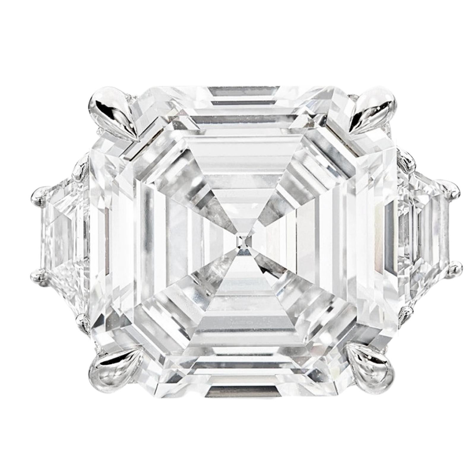 GIA certified Asscher cut diamond, the epitome of refinement and investment value. Meticulously crafted and set in solid platinum, this exceptional diamond is accompanied by two captivating trapezoid diamonds, creating a masterpiece of timeless