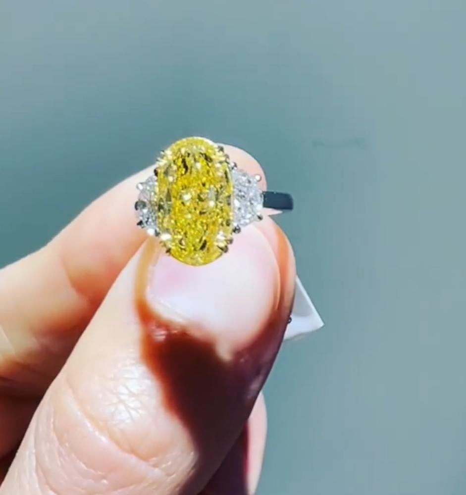 Taille émeraude Bague sans défaut à trois pierres en diamant jaune fantaisie de taille ovale de 4 carats certifié par le GIA en vente