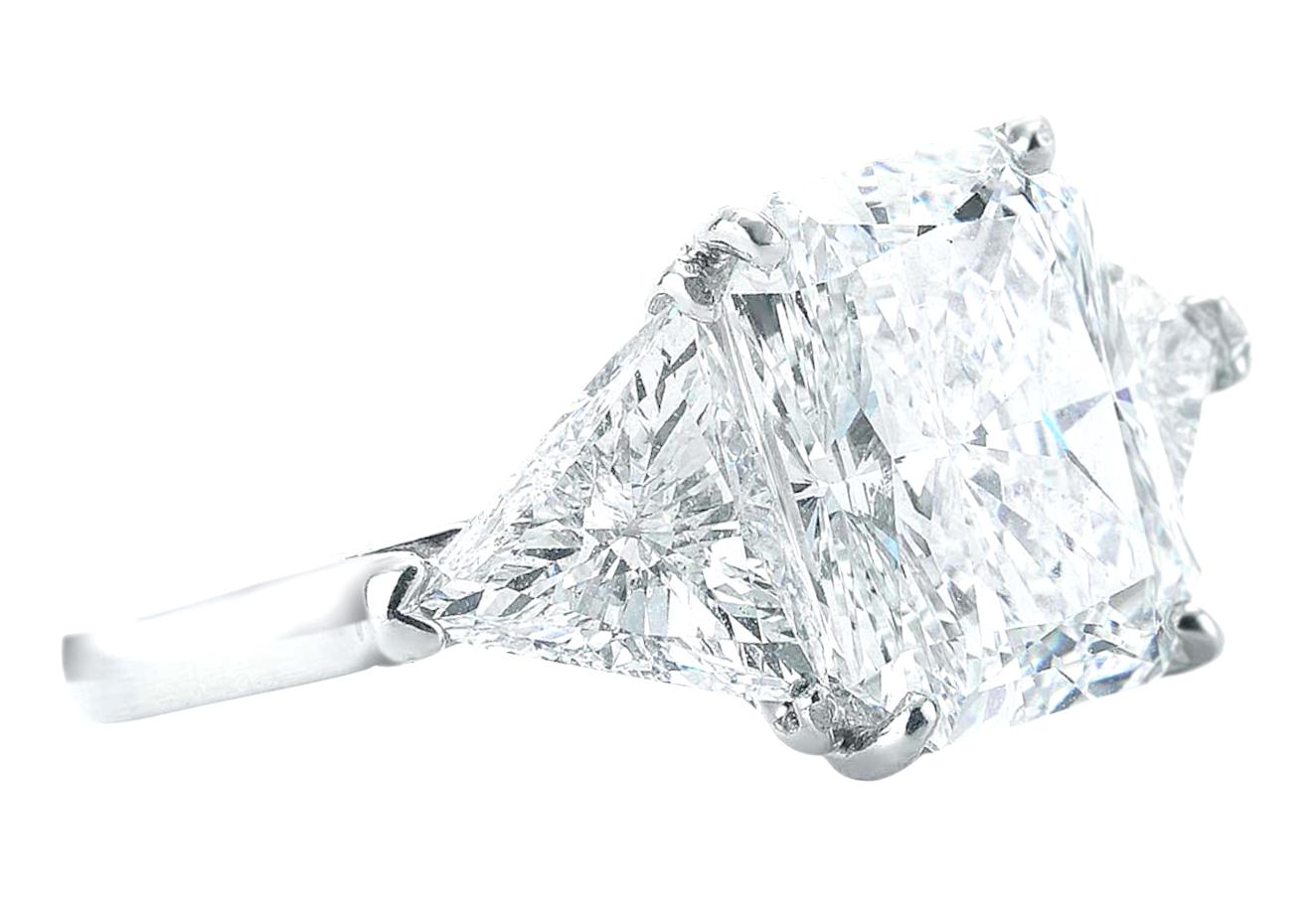 Exquise bague en diamant à trois pierres composée d'un diamant radiant de 4,02 carats certifié par le GIA et de deux diamants latéraux de taille trillion aux excellentes proportions.
Chaque diamant taille trillion pèse environ 1 carat.

Vous