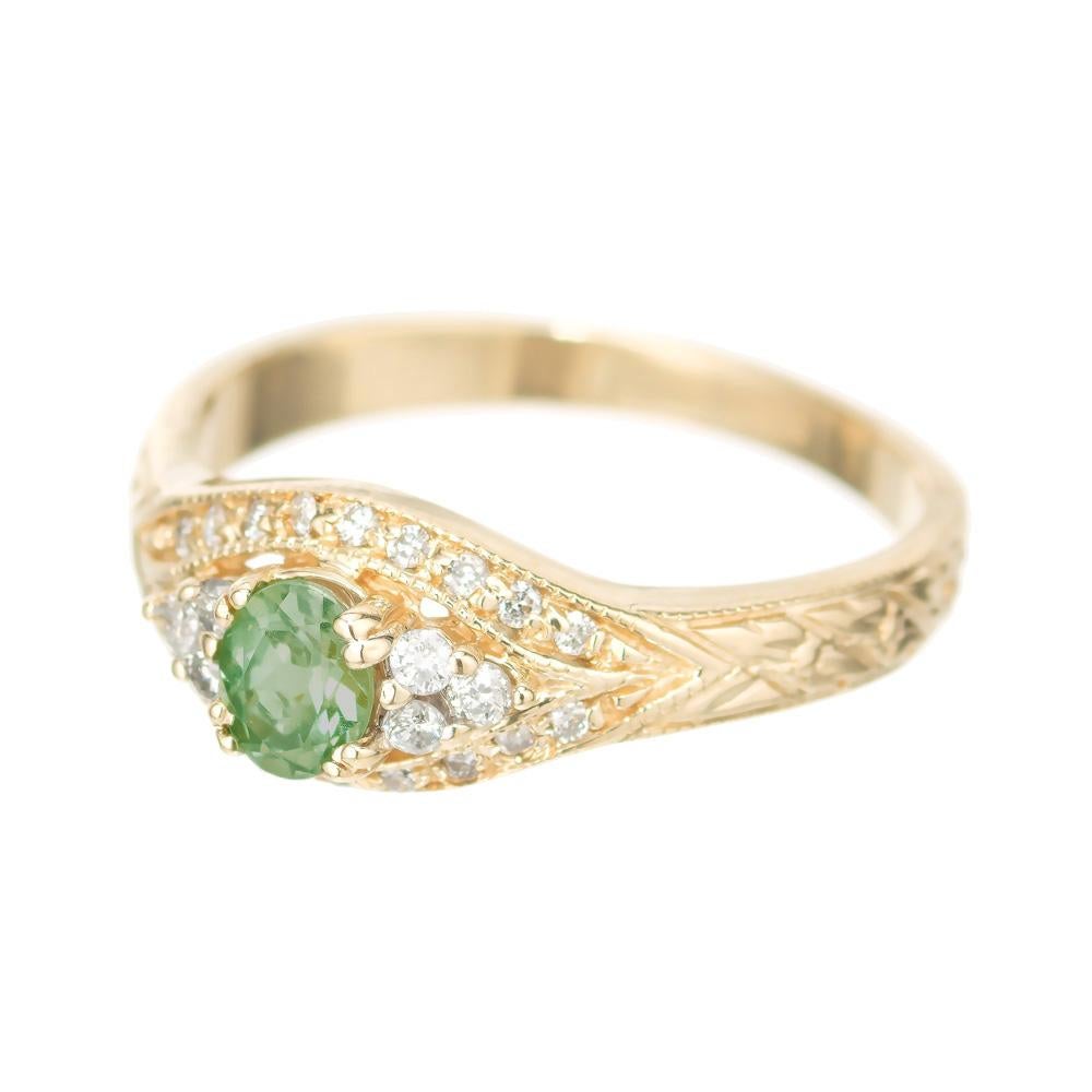 Chrysoberyl and diamond engagement ring. GIA certified .40ct oval green chrysoberyl center stone set in a 14k yellow gold setting with 6 round diamonds and 18 round pave set diamonds. Hand engraving along both sides of the shank. 

1 oval green