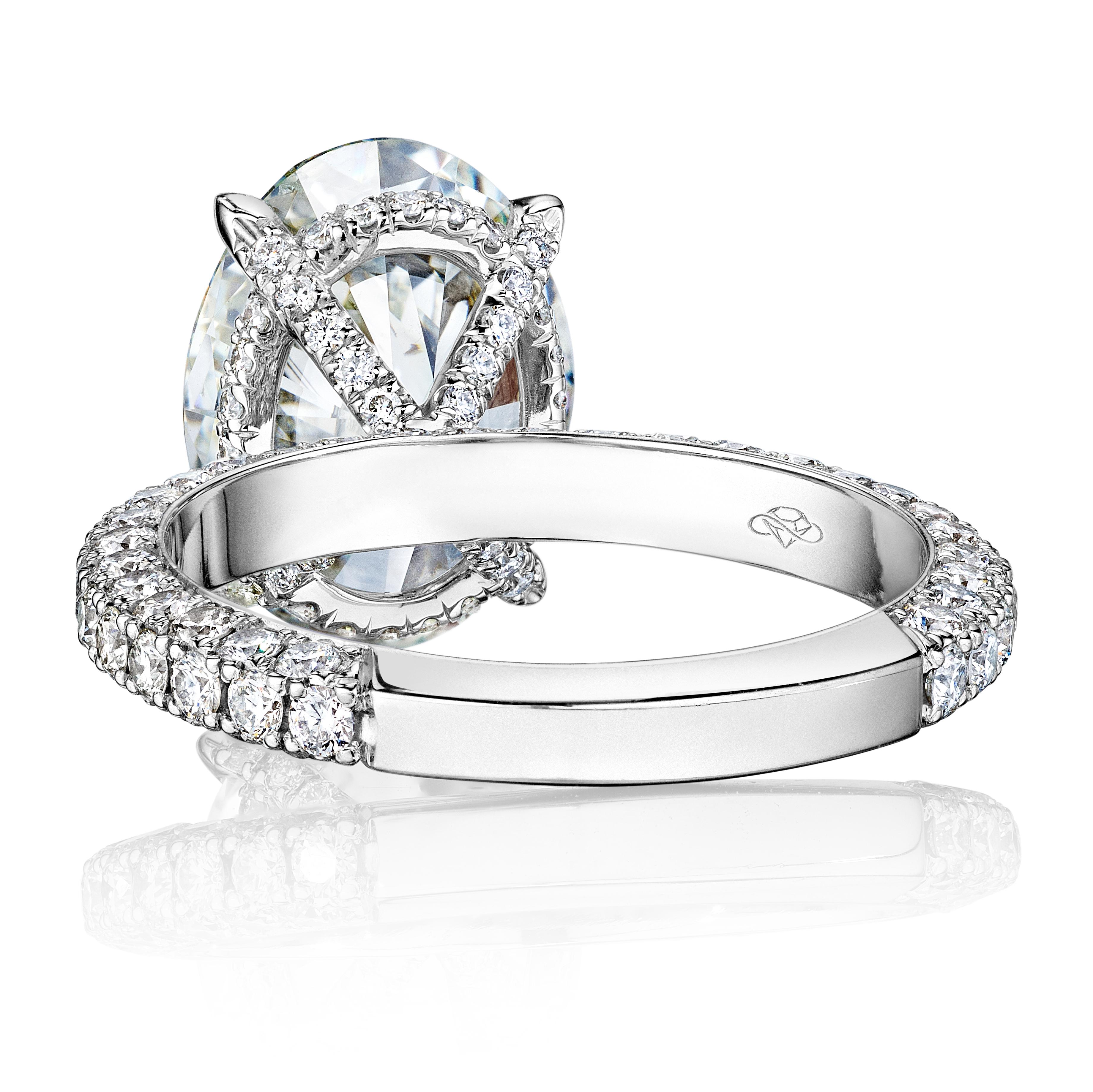 Discover unmatched elegance with this exquisite, custom-made platinum engagement ring, prominently featuring a breathtaking 4-carat oval diamond. The central gemstone, meticulously selected for its superior cut, clarity, and color, boasts a symphony