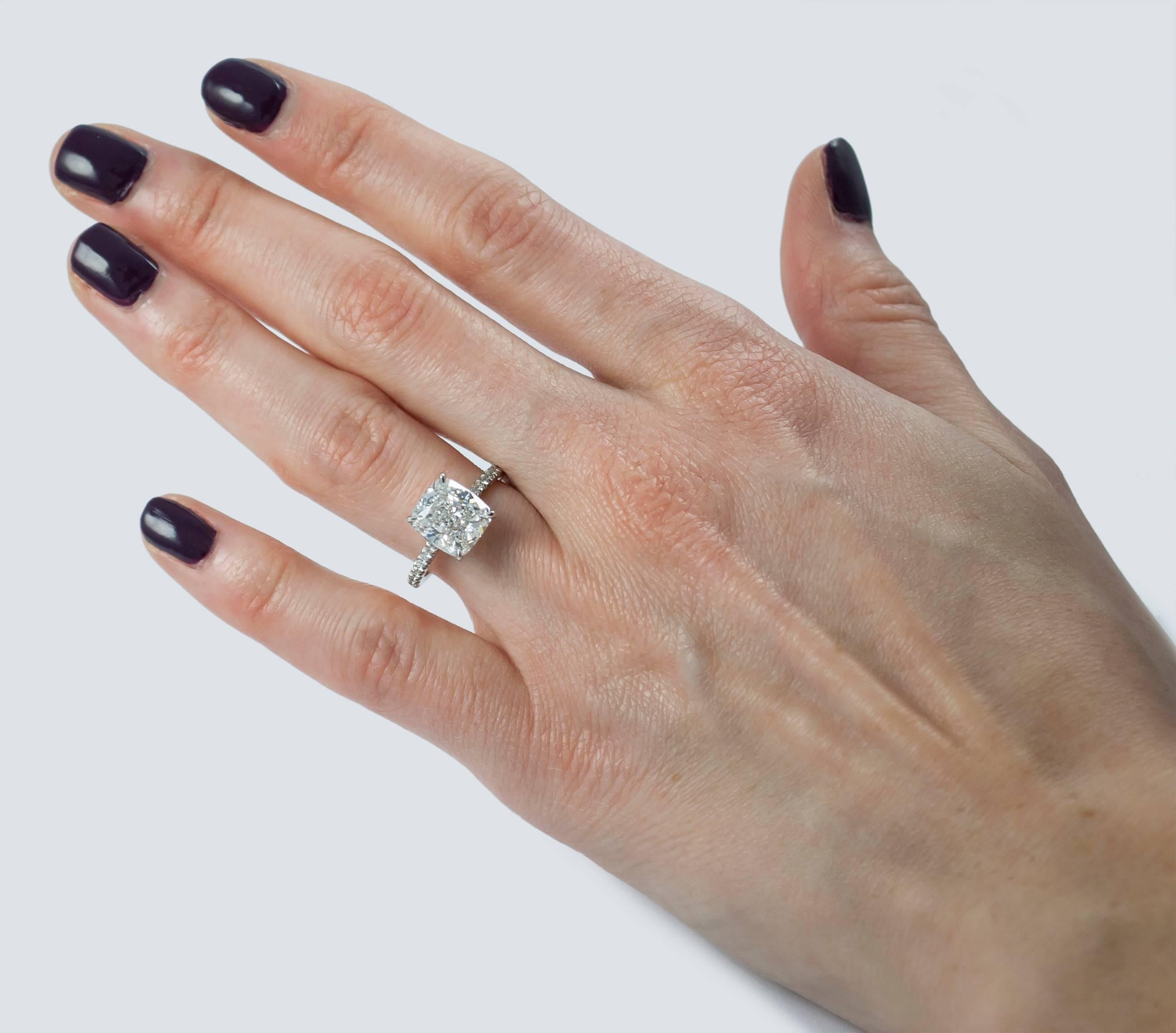 This solitaire from the J. Birnbach collection features a GIA certified 4.01 carat cushion modified brilliant, graded with D color and SI1 clarity. The diamond is set on a platinum mounting with pave diamonds 3/4 down the band for added elegance and
