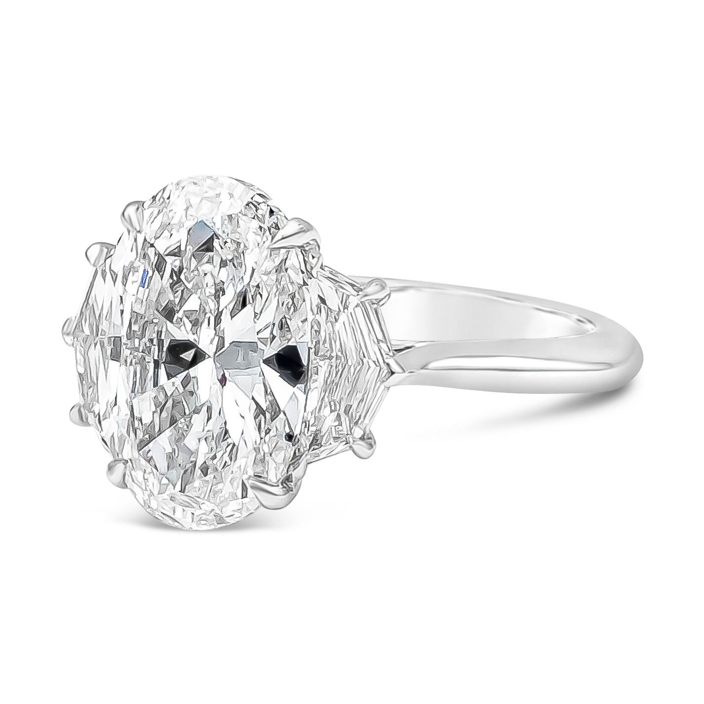 A stunning three-stone engagement ring showcasing a GIA Certified oval cut diamond weighing 4.02 carats total, D Color and VS1 in Clarity. Flanked by 2 epaulette diamonds on each side weighing 0.59 carats total, E-F Color and VS in Clarity. Made