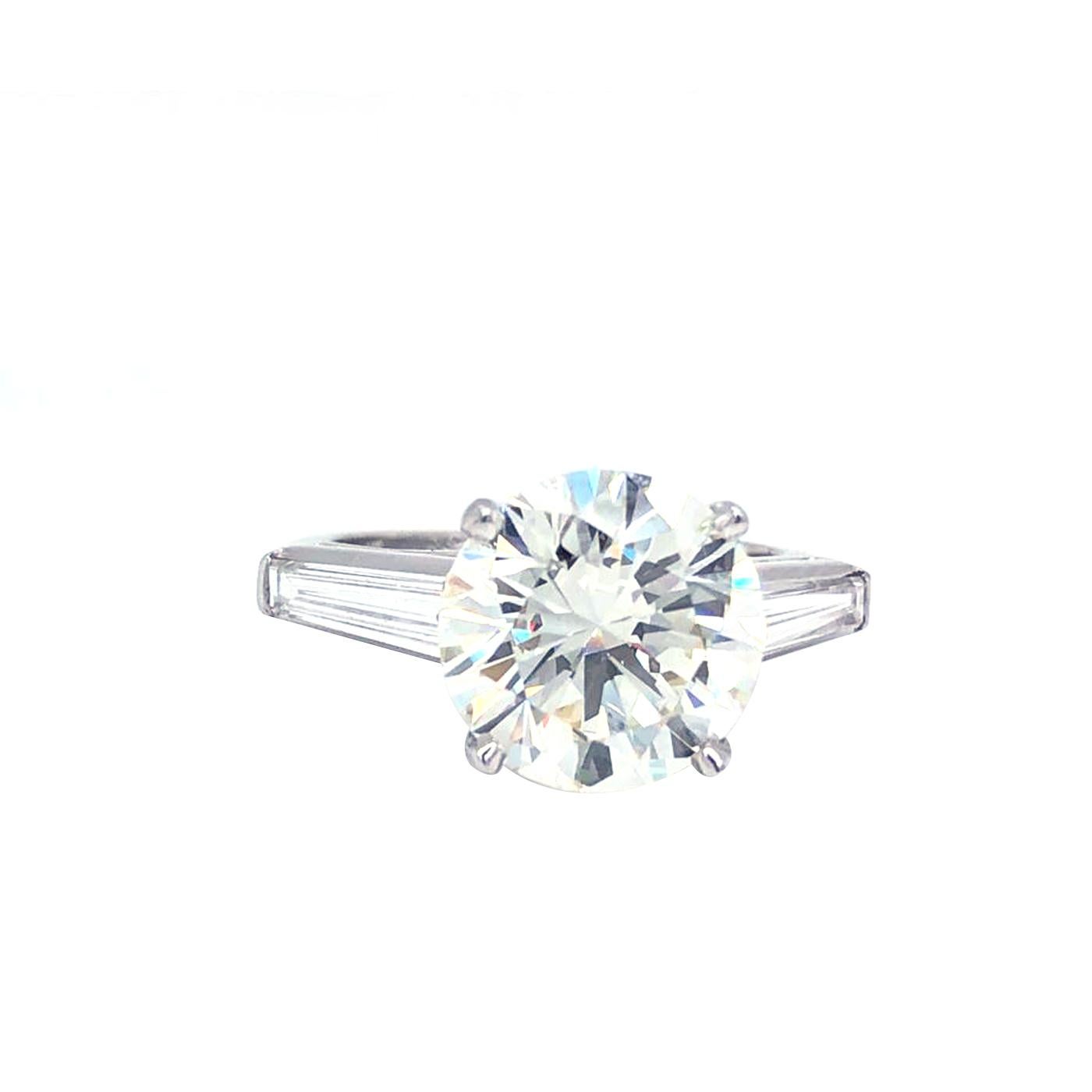 Classic Platinum Diamond ring 4.03 Carat center Round Brilliant Certified by Gia as L - Color , Vs1 Clarity, Excellent - Cut , Excellent - Polish , Excellent - Symmetry and accented by two tapered baguette cut diamonds , Totaling 0.72 carat H color