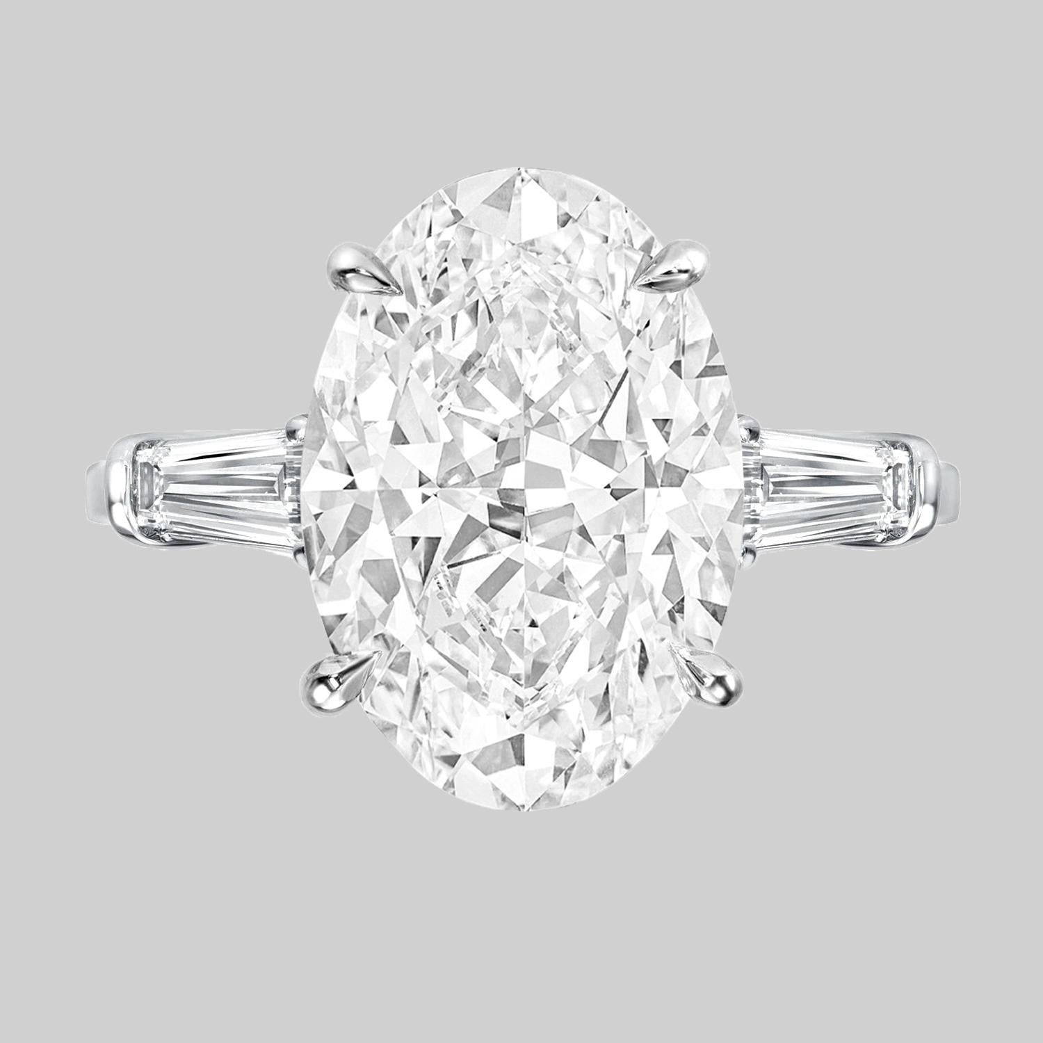 An exquisite GIA certified 4.04 carat oval diamond ring the diamond has excellent proportions and ideal shape it has been mounted with two delicate prongs and tapered baguettes set in solid platinum