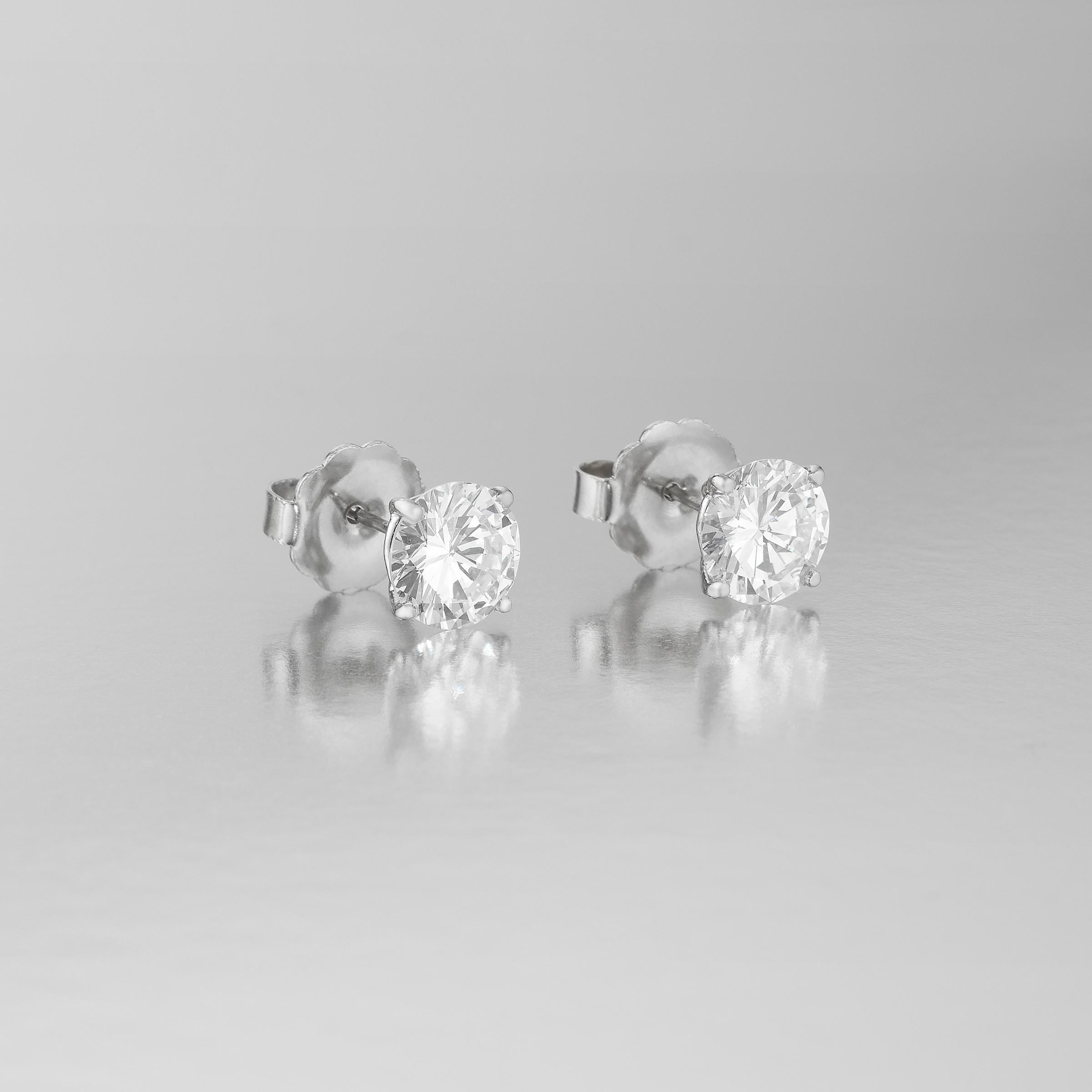 Exceptional diamond solitaire stud earrings showcasing 2 spectacular GIA Certified round brilliant-cut diamonds weighing 4.10 carats in total. They are accompanied by 2 GIA certificates showing the 2.10 carat round brilliant diamond is F color / VS2