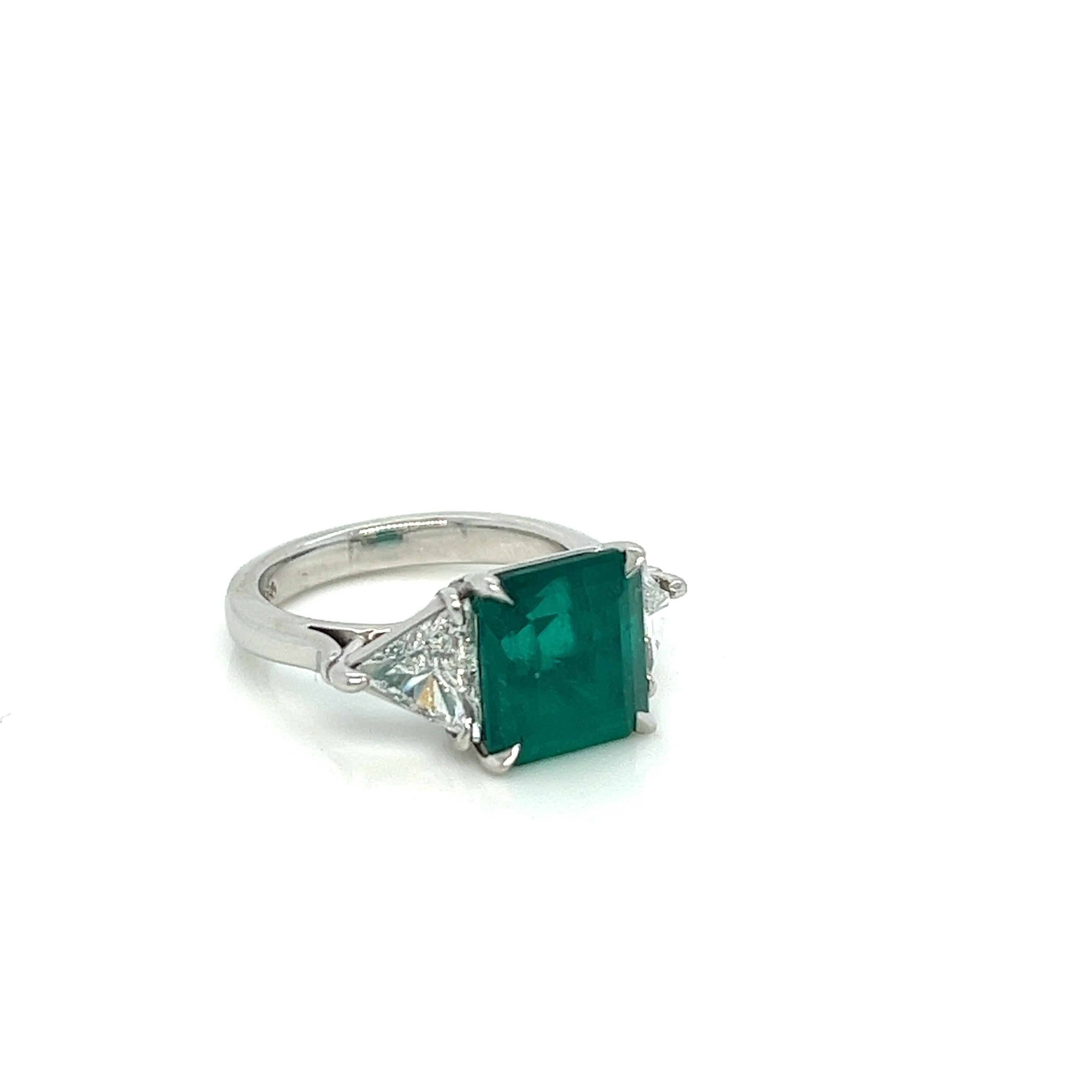 We couldn't help but say that this cocktail estate ring screams green with envy! The classic three stone design is centered by a 4.10 carat Colombian emerald graded by GIA. It's amazing rich green color just pops against the two super white (F