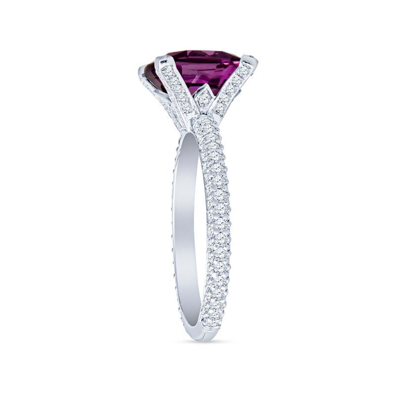 Elevate your jewelry collection with this exquisite ring featuring a vibrant 4.11 carat cushion cut natural purplish pink sapphire, elegantly set in a luxurious platinum band. The stunning side diamonds, totaling 1.20 carats, beautifully complement