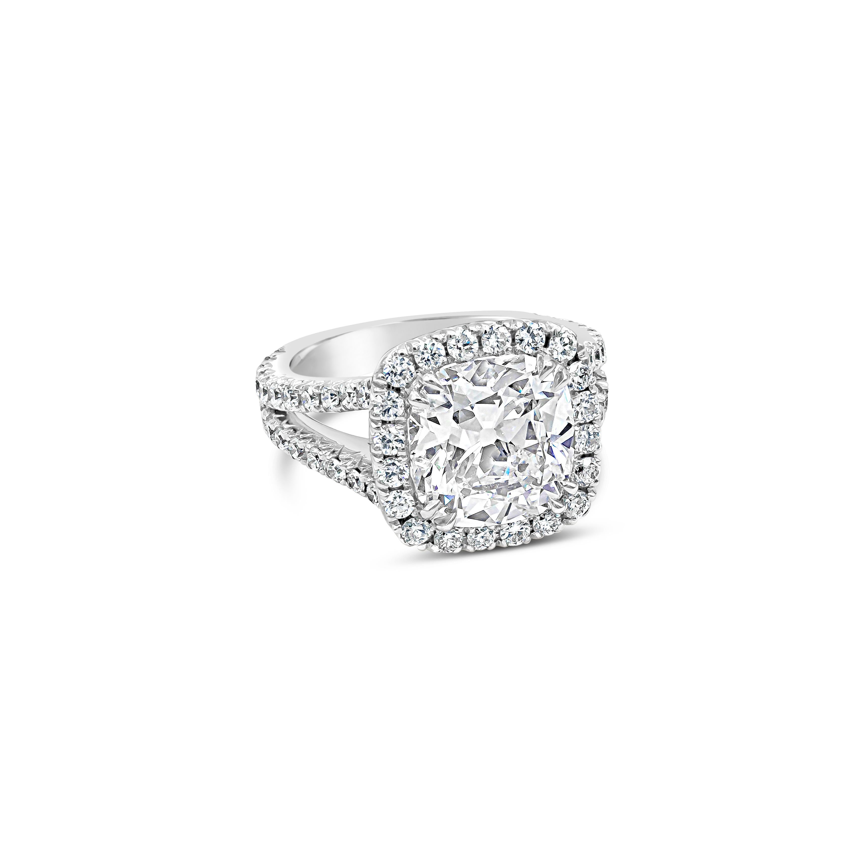 An elegant and vibrant halo engagement ring, featuring an impressive cushion cut diamond of 4.11 carats. This center stone is certified by GIA as G color and SI1 clarity. It is surrounded by a single row of round brilliant cut diamonds of 1.40