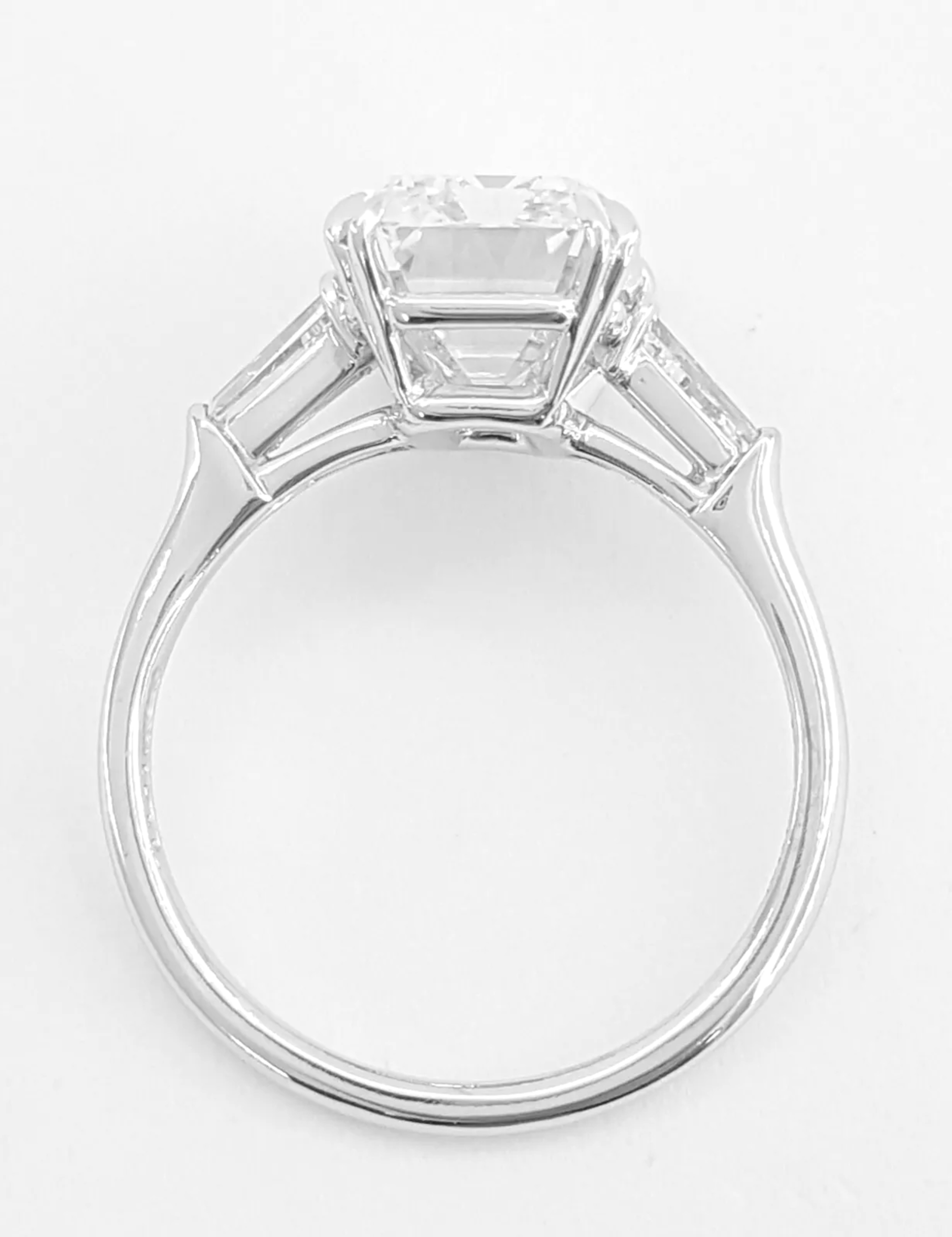 stunning engagement ring featuring a total diamond weight of 4.11 carats. The centerpiece is a gorgeous long natural emerald cut diamond that weighs 4.11 ct, graded as D in color and Flawless in clarity. 
There are two tapered baguette cut side