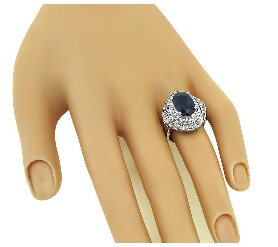 Este es un encantador anillo de platino. El anillo está centrado con un precioso zafiro de talla oval certificado por el GIA que pesa aproximadamente 4,11 ct. El zafiro está acentuado por brillantes diamantes talla baguette y redonda que pesan