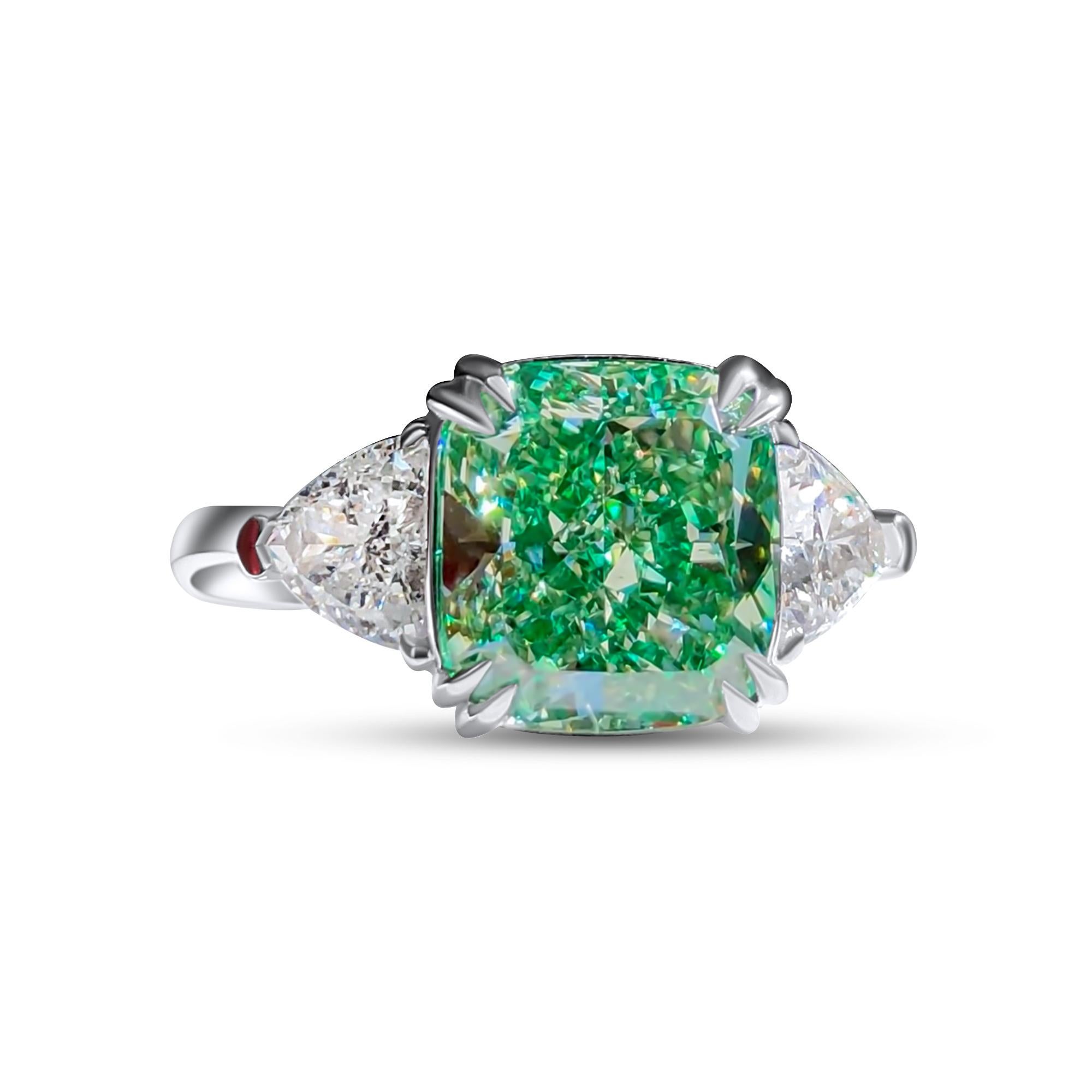 We invite you to discover this elegant ring set with a GIA certified cushion cut green diamond of 4,12 carats enhanced with 2 trillion cut colorless diamonds.
The wonderful green color of the main diamond makes this ring rare, unique and very