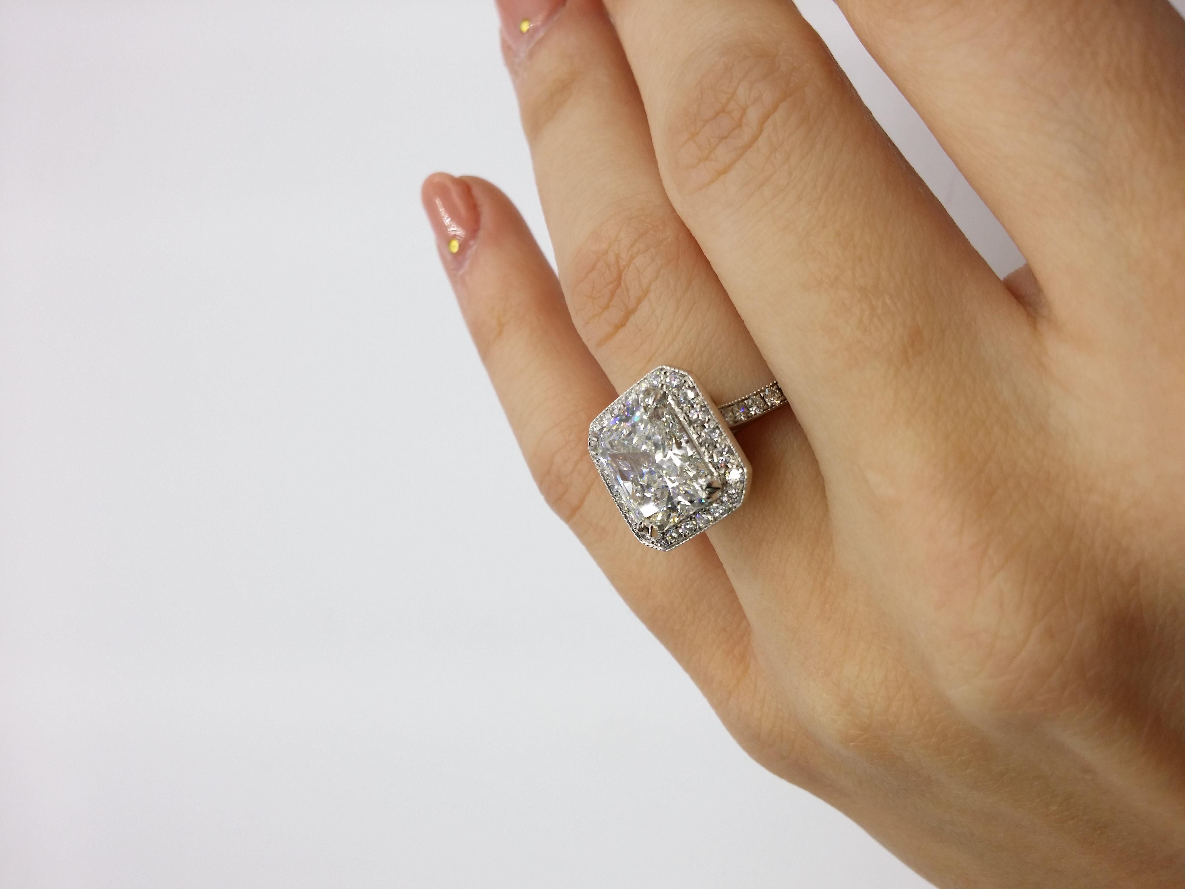 Platinum diamond ring, features 4.18 Carat Radiant in the center surrounded by 0.70 Carats of diamonds around.

