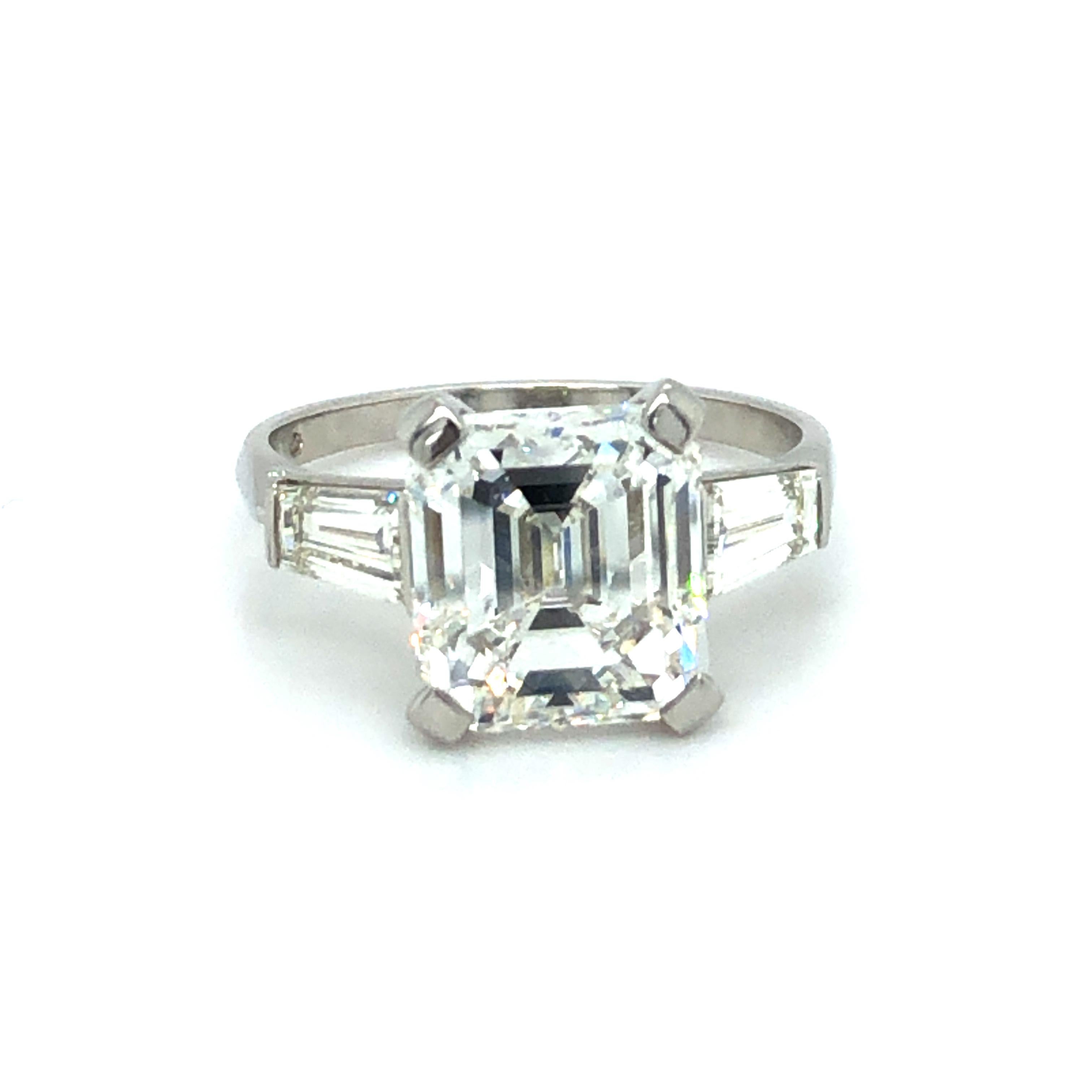 Beautiful and timeless solitaire diamond ring in platinum 950 by Swiss jeweller Gübelin.
Set with a 4.19 carat emerald-cut diamond of H colour and vs1 clarity. Flanked by two trapezoid shaped diamonds of G/H colour and vs clarity, total weight