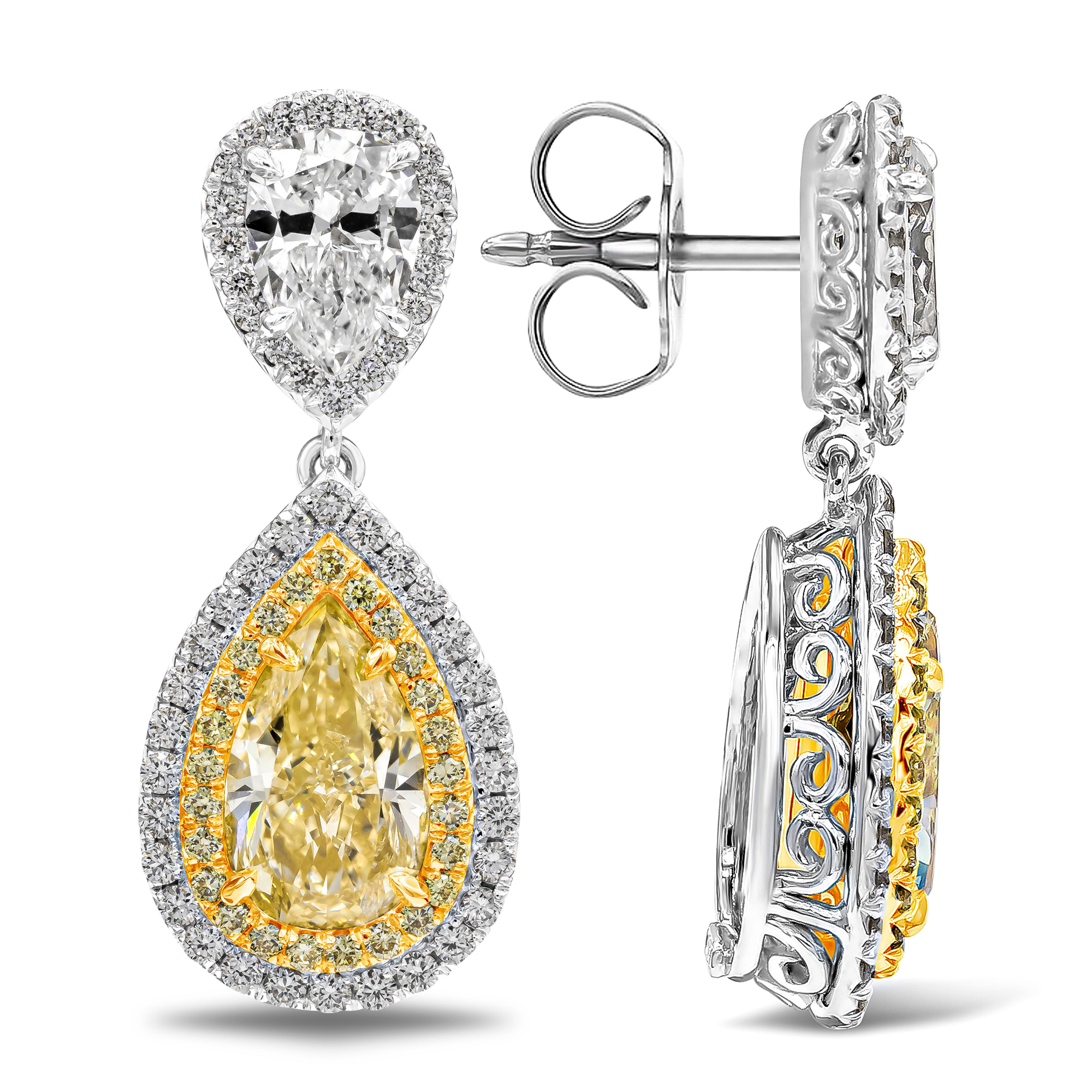 Showcasing a color-rich and elegant two pear shape yellow diamonds weighing 2.13 and 2.06 carats approximately, surrounded by two rows of round brilliant diamonds in a halo design. Suspended on a pear shape white diamond accented by a row of round