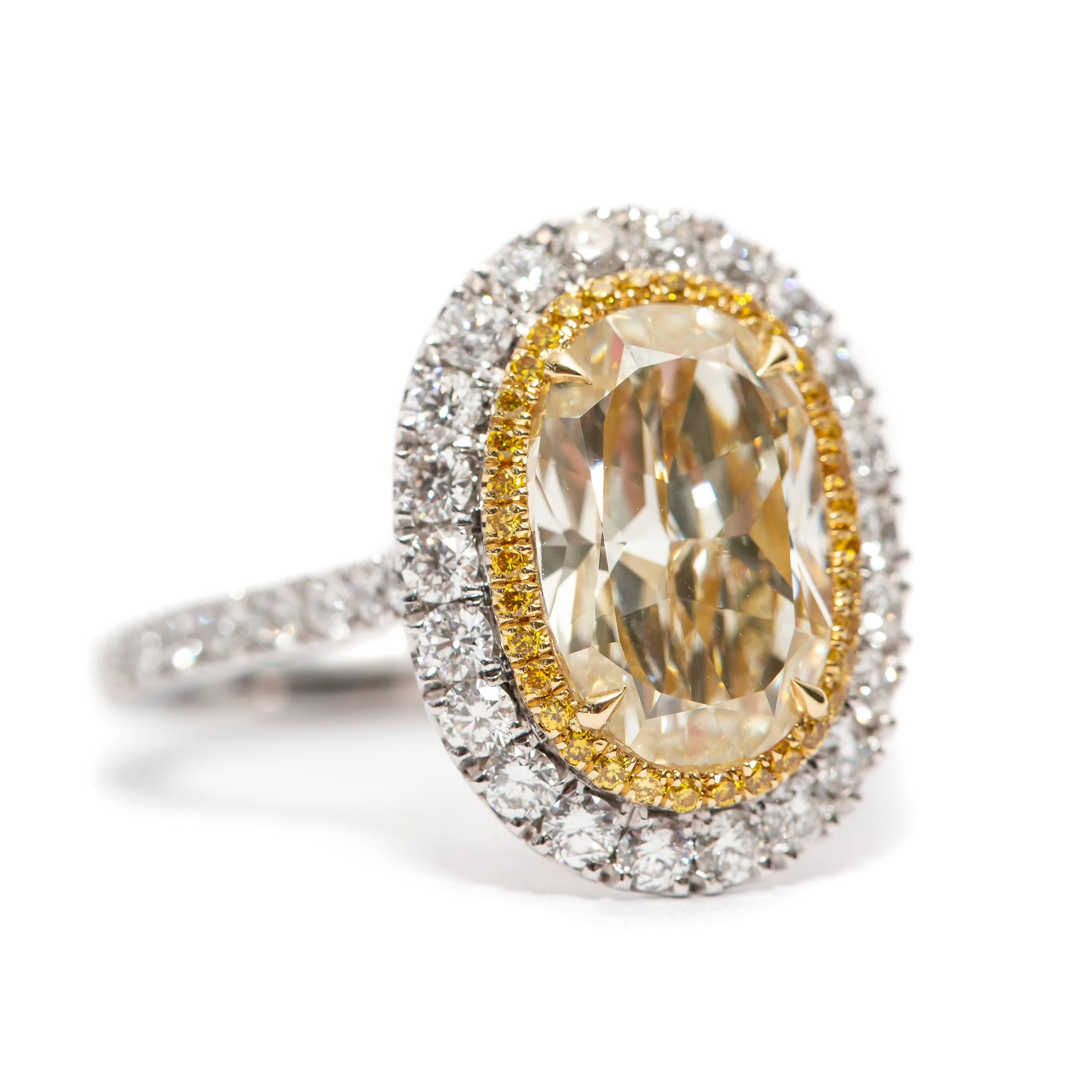 This Spectacular GIA Certified 3.16 Carat Yellow Oval Diamond Color N Clarity SI1 which is set in the center with 0.93 Carat of White Round Brilliant cut Diamonds on the Outer Halo flowing down the side of the shank, the inner halo features 0.13