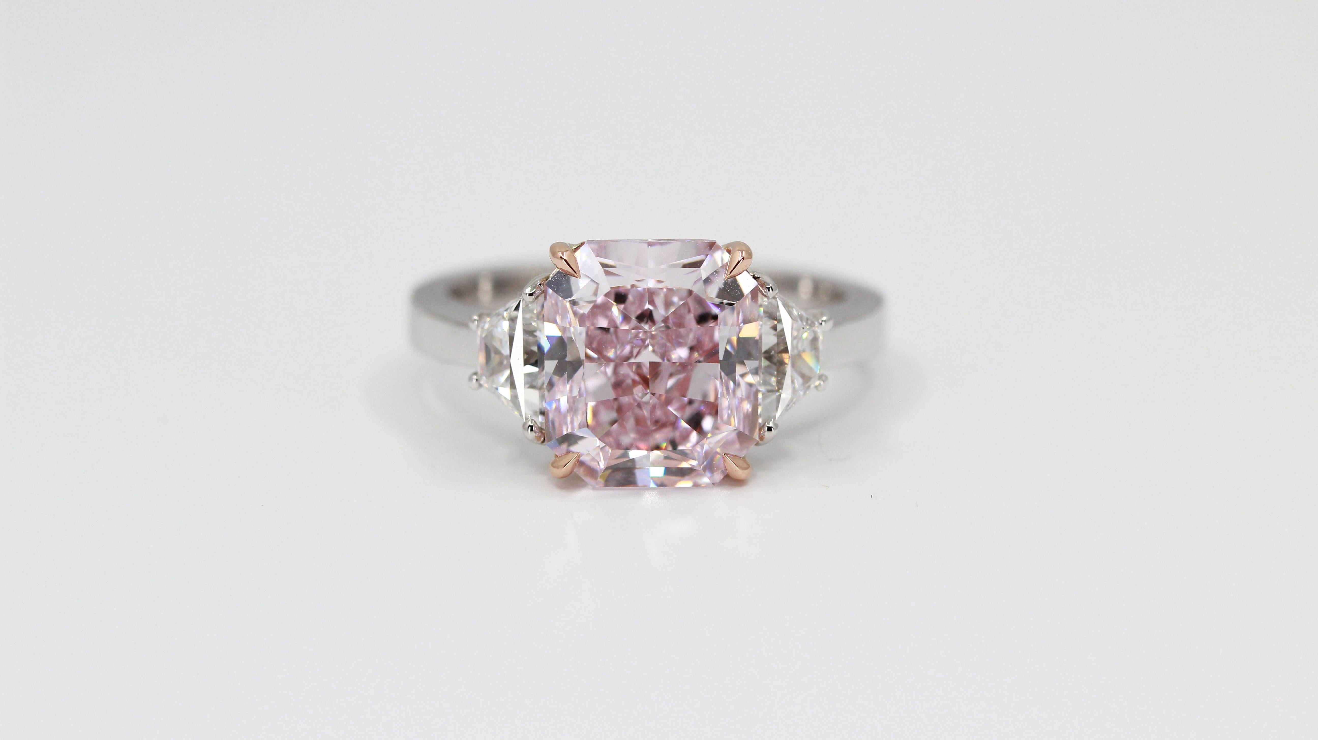 Eine von einer Art extrem seltene GIA zertifiziert 4,24 Karat Fancy Purplish Pink Internally Flawless Radiant Cut Diamond.
Flankiert von zwei trapezförmigen Diamanten der Collection Farbe VS Reinheit von insgesamt 0,85 Karat, eingefasst in einen