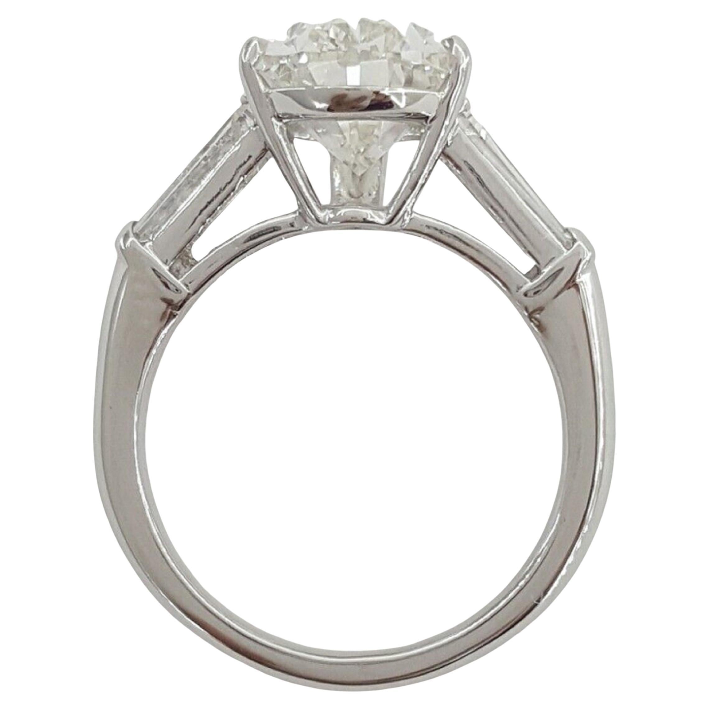 Certainly, here is the description for the ring with a platinum setting and two tapered baguettes on the sides of the main diamond:

This exquisite ring features a stunning GIA certified Pear-shaped diamond as its centerpiece, creating an air of