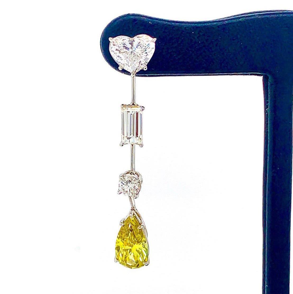 These intricate earrings feature a unique variety of various shapes diamonds mounted in hand made platinum. 
On the ear sit Two GIA certified heart brilliant cut diamonds with 1.85 total carat weight. E-G color SI2 clarity. 
Suspending off the ear