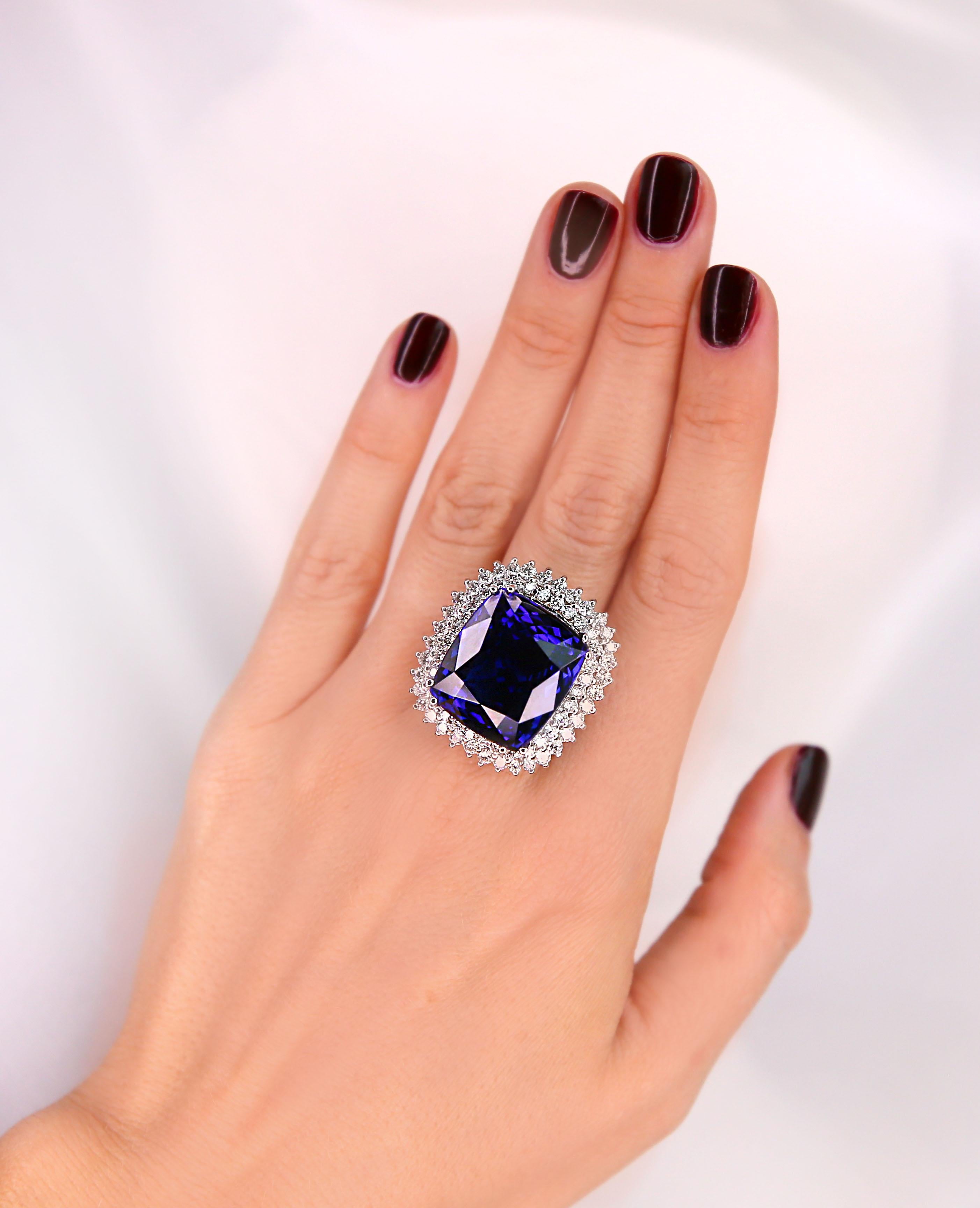 White gold ladies cast tanzanite and diamond ring with a bright polish finish. 
The featured tanzanite is set within tiered diamond bezels, completed by a two and one-half millimeter wide band. 
Identified with markings of 