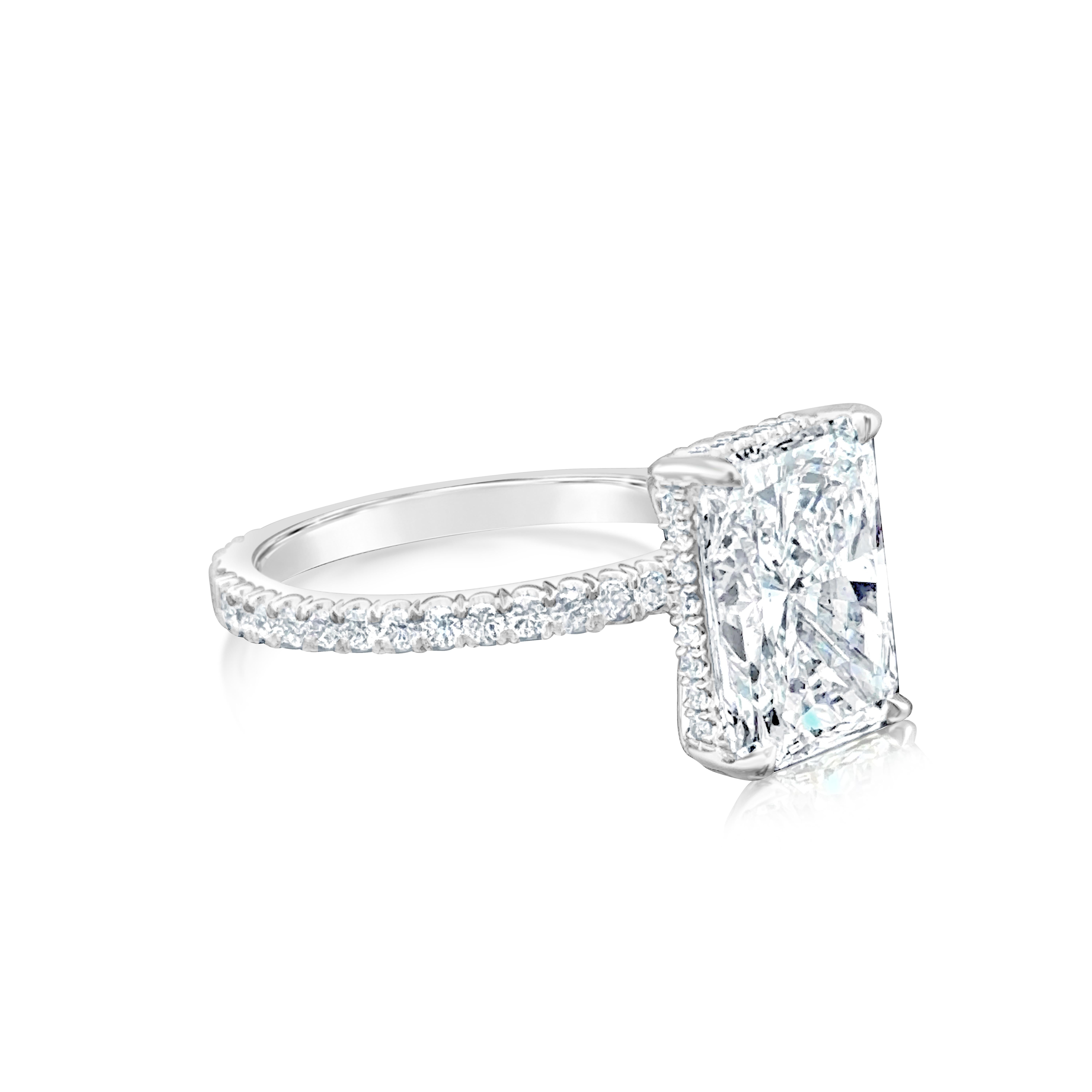 Uno splendido anello di fidanzamento con un diamante a taglio radiante allungato di 4,40 carati certificato da GIA con colore D e purezza SI2, incastonato in una classica montatura a quattro punte. Accentuato da diamanti a taglio rotondo per un peso