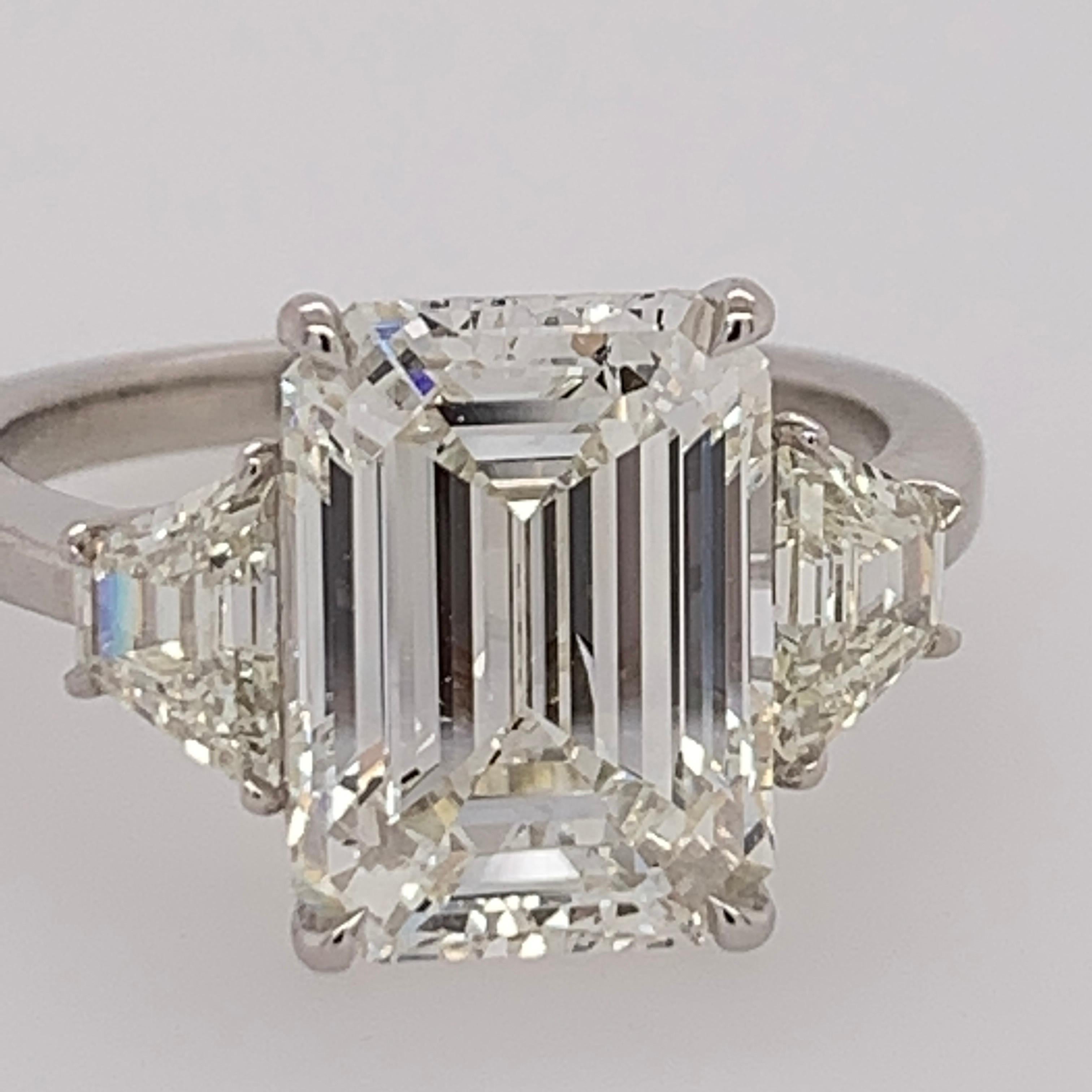 A stunning Platinum & Natural Diamond Engagement Ring. The centerstone is a 4.40 carat rectangular shaped emerald cut, GIA certified as a J in color and VS2 vs2 in clarity. The color and clarity are very pleasant, and the measurements of