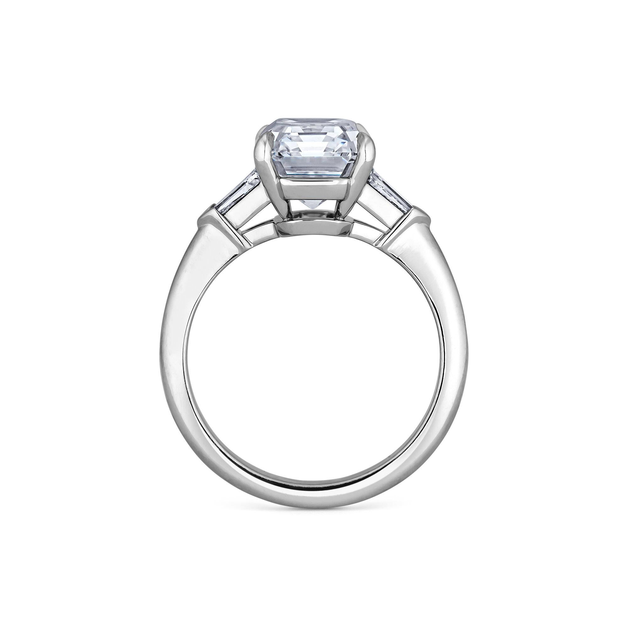 This quintessentially elegant 4.42 carat emerald cut diamond engagement ring will quickly become a girl's best friend. Luxuriously set in a handmade mounting with four prongs and side bullet cut diamonds, this extraordinary ring will take your