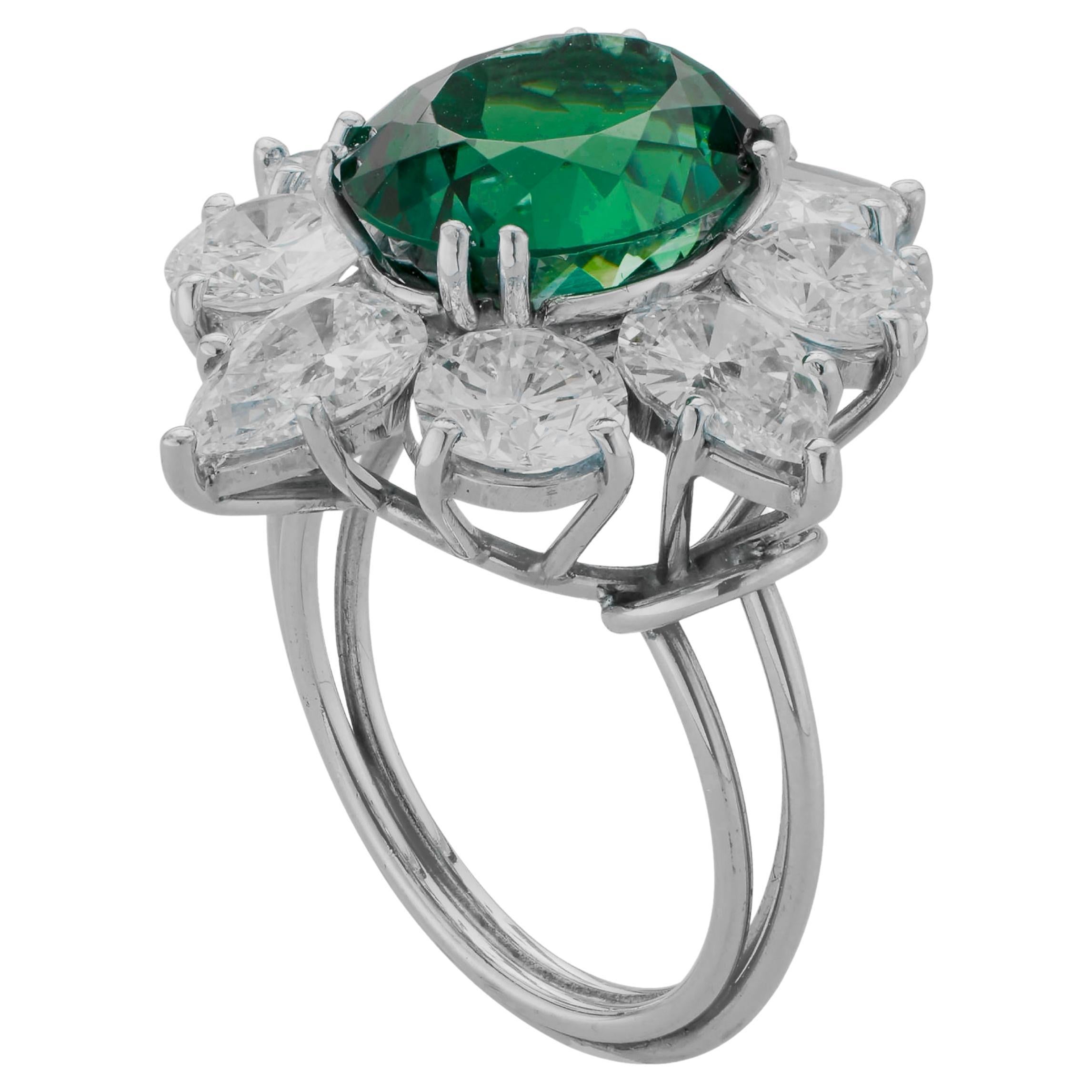 Centering on a colombian emerald framed by round and pear shaped diamonds

Metal: Platinum 
Diamonds: 4 round and 4 pear shaped diamonds with approximate total weight of 4 carats
F/G color
VS clarity







