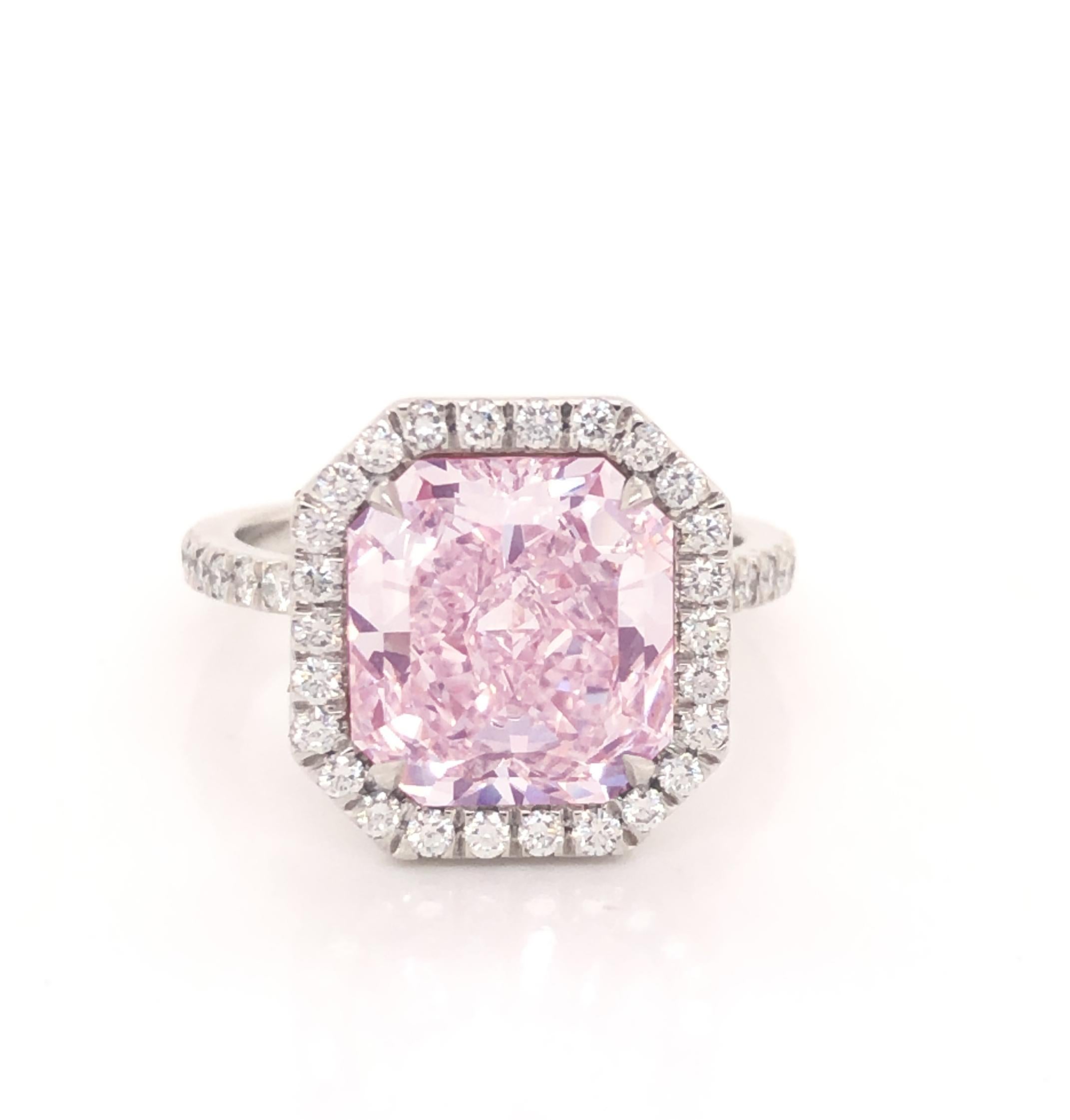 Beautiful hand made ring crafted in platinum by master jewelers. The focal point of the ring is one of the rarest diamonds in the world. A natural pink diamond. The center stone is one radiant cut diamond. Accompanied by a GIA certificate, the