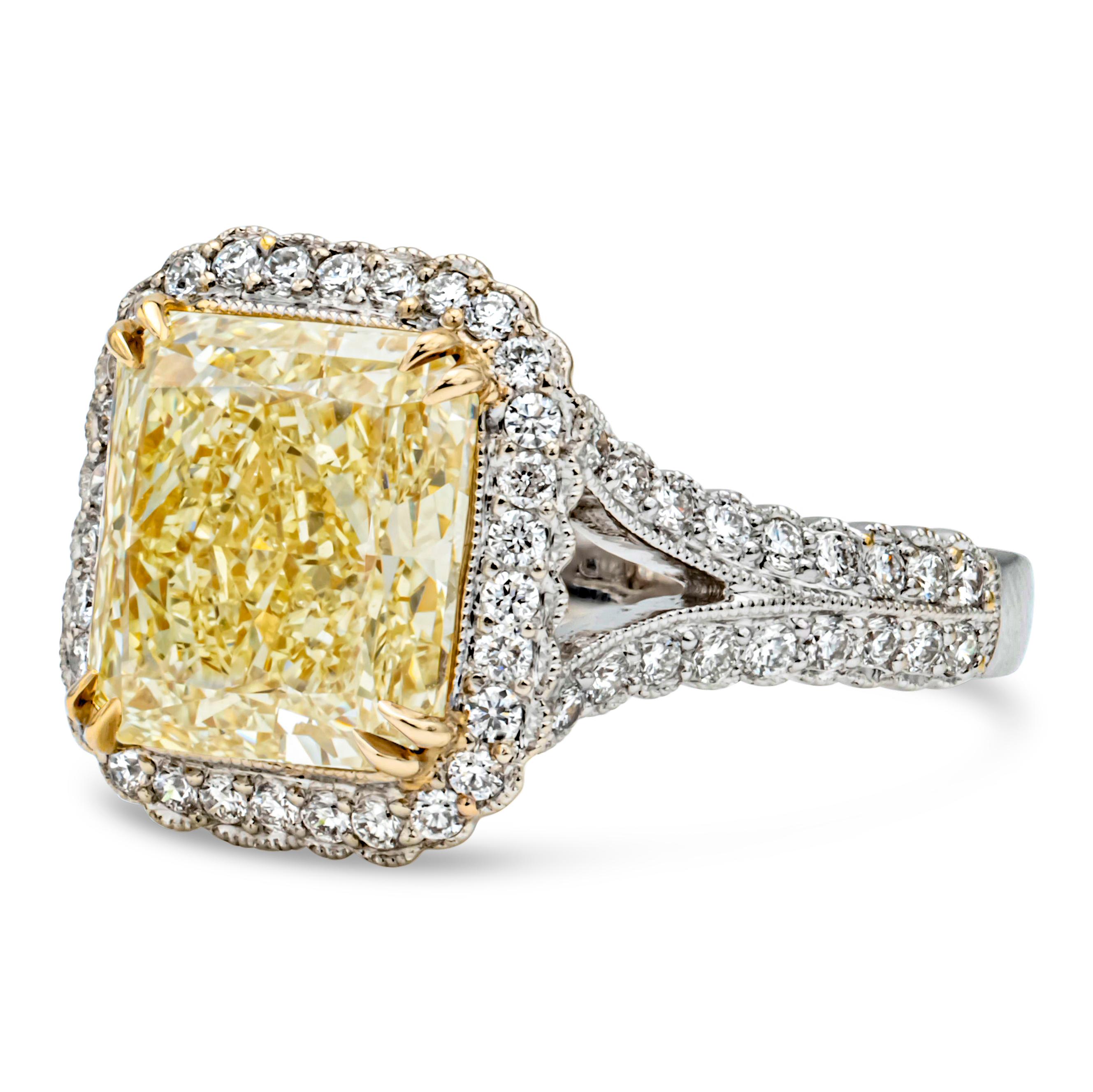 This elegant and vibrant halo engagement ring features a 4.51 carats radiant cut diamond certified by GIA as fancy yellow color and VS1 in clarity, set in an eight prong 18k yellow gold basket setting. Surrounded by a single row of round brilliant
