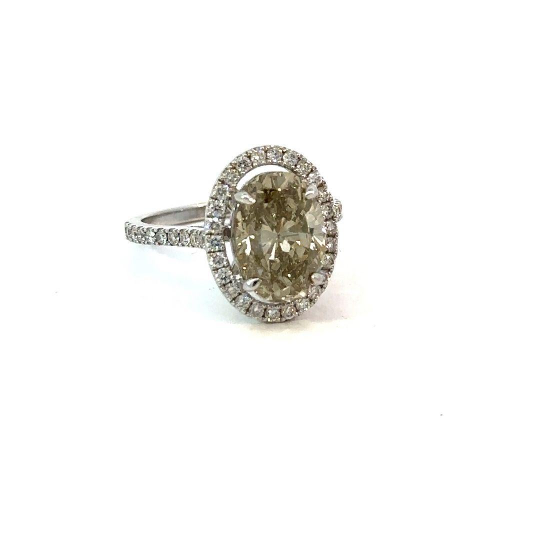 GIA 4.56 Carat Fancy Brownish Greenish Yellow Oval Brilliant Diamond Engagement Ring

This masterpiece of nature boasts a rare and captivating blend of hues, evoking the richness of an autumn sunset. Its elegant oval cut, meticulously crafted to