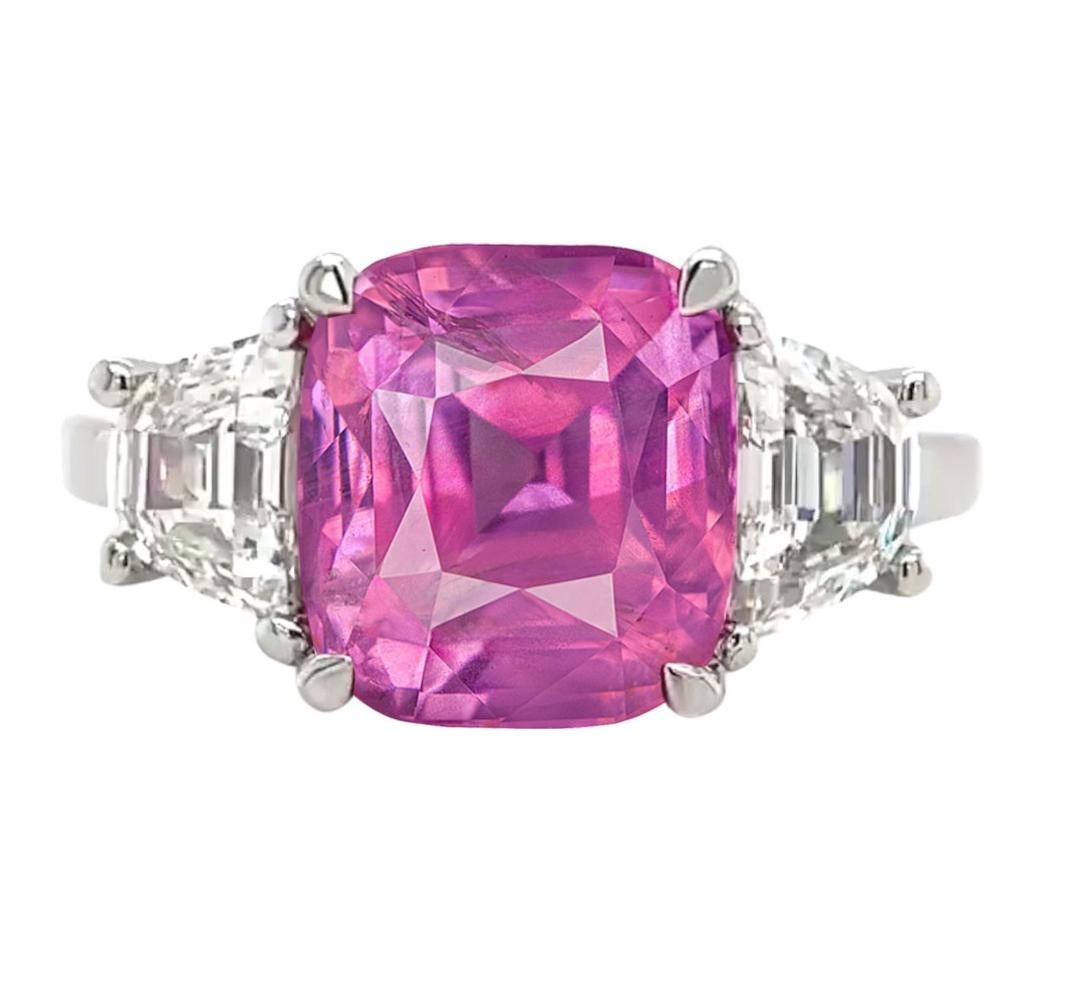 Indulge in the allure of timeless elegance with this exquisite GIA Certified ring. 
A resplendent 4.57-carat Pink Sapphire, sourced from the famed mines of Sri Lanka, formerly known as Ceylon, takes center stage. 
The captivating hue of the Pink
