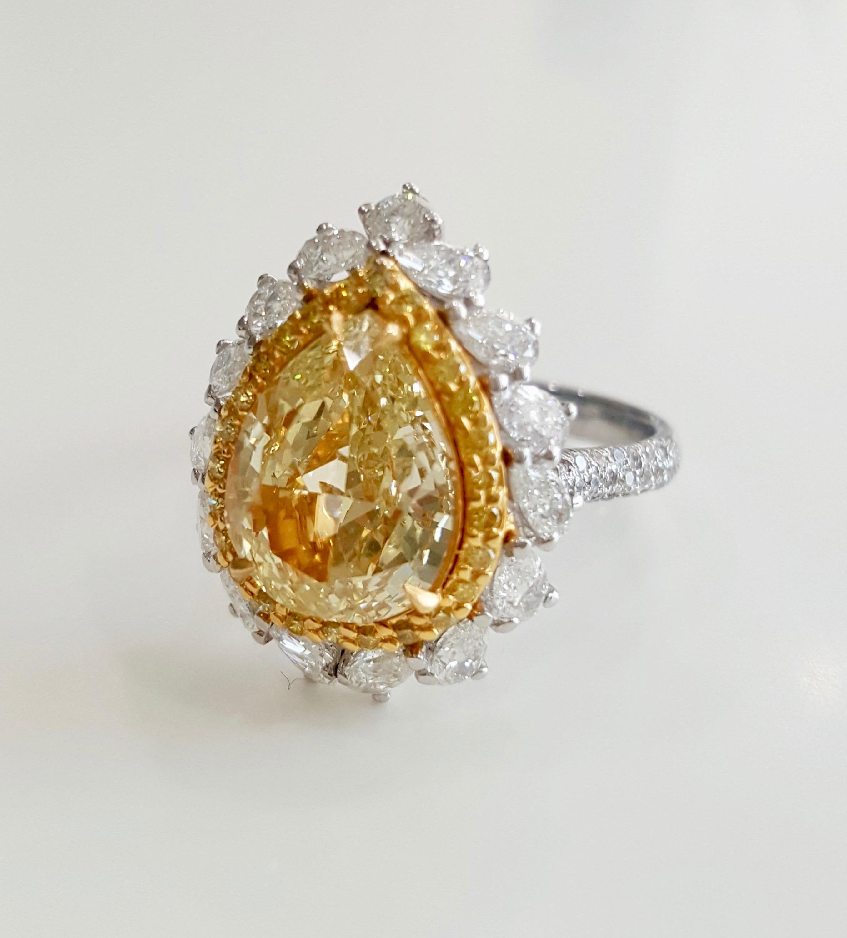 Custom designed diamond engagement ring by Moguldiam Inc with GIA certified natural fancy yellow pear brilliant cut diamond in the center weighing 3 carat with SI 2 clarity set in double halo mounting with a row of small  yellow diamonds and small