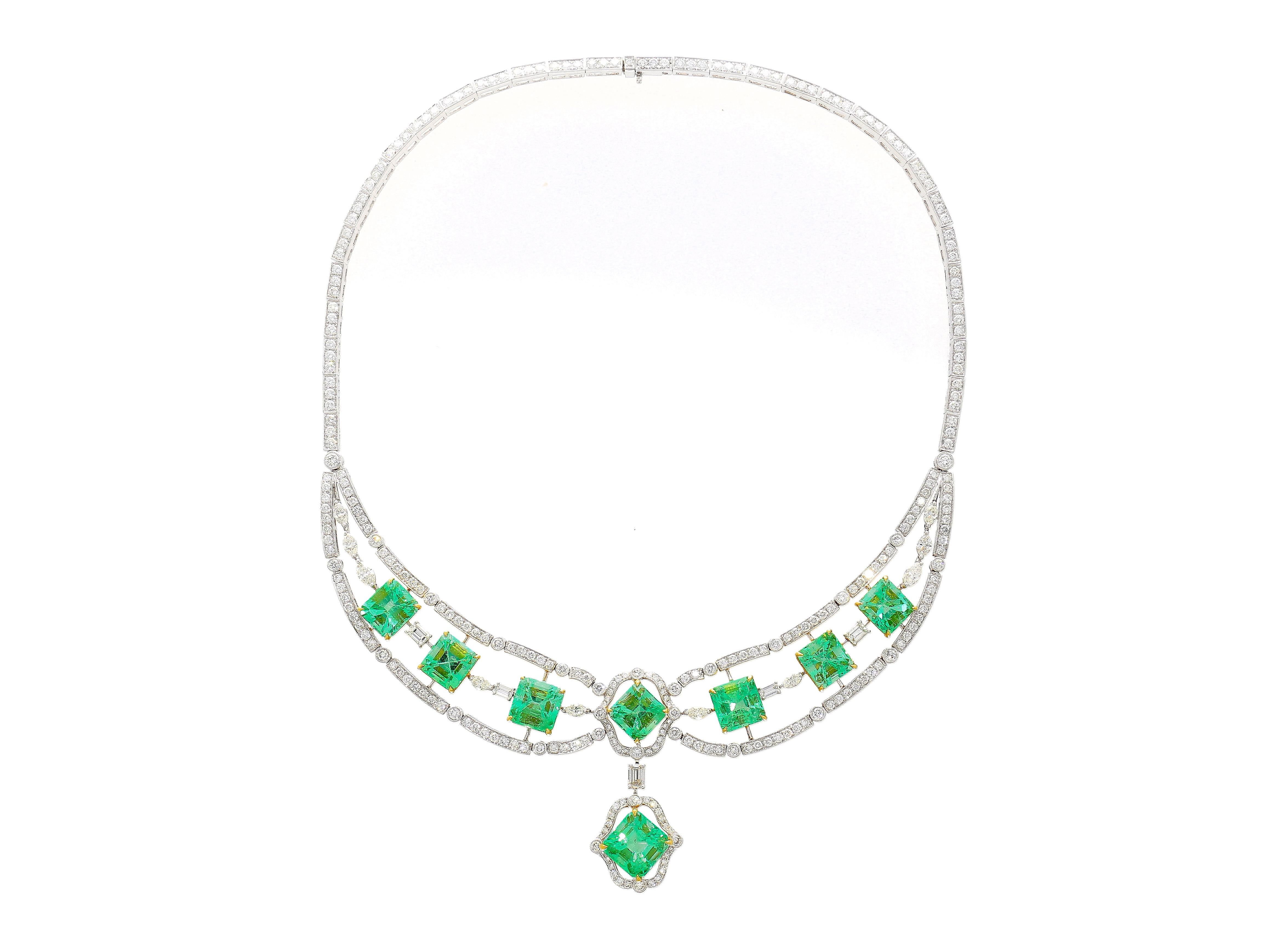 18K White and Yellow Gold Chandelier Necklace, a true embodiment of luxury. Weighing 55.87 grams and spanning 15 inches, this masterpiece centers a captivating 6.21 Carat Octagonal Emerald Cut Emerald from Colombia.

Featuring eight emerald side