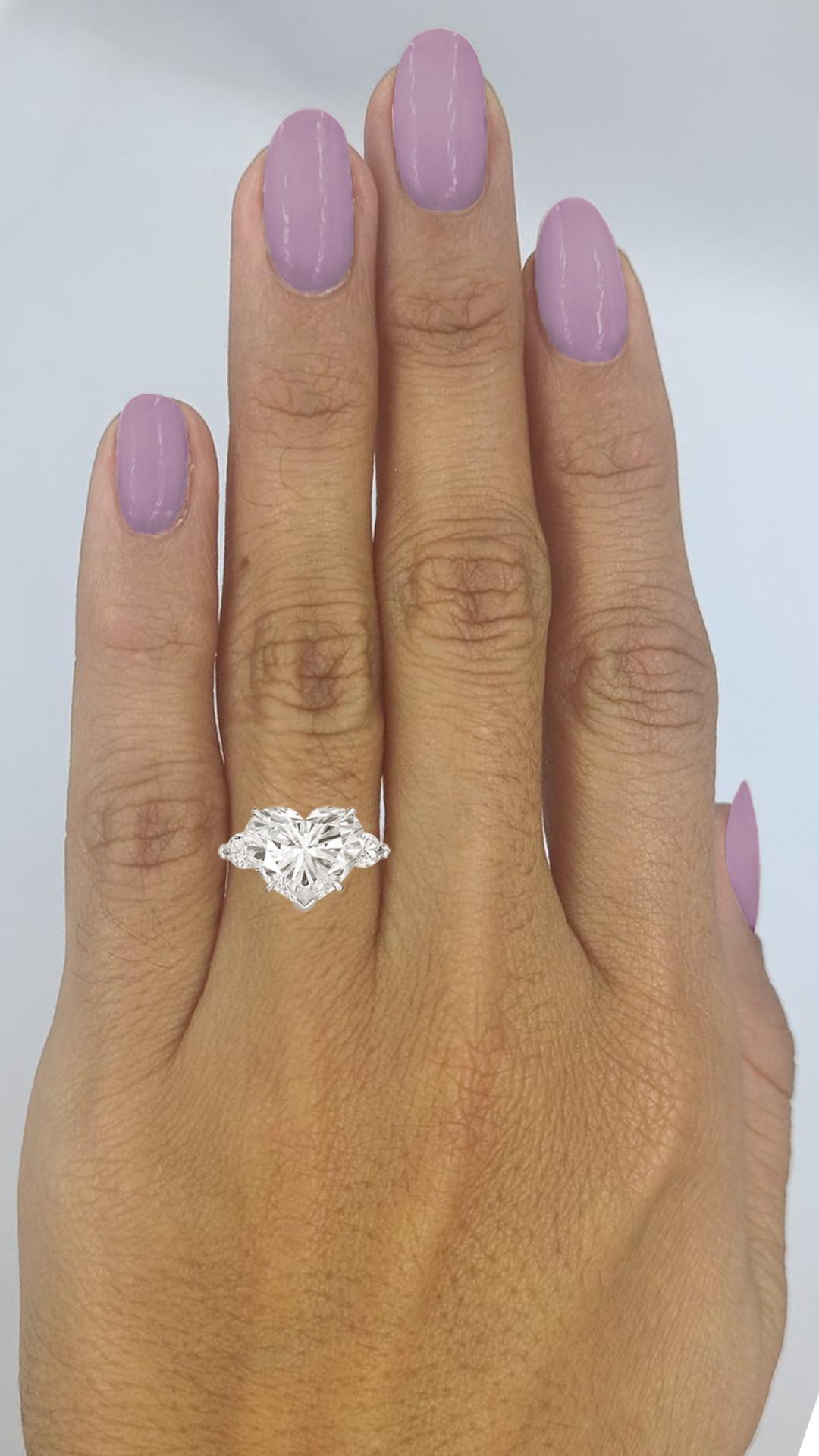 Cette bague exquise est ornée d'un époustouflant diamant taillé en cœur de 4,03 carats, magnifiquement serti dans un luxueux or blanc 18 carats. 

Le diamant central présente un grade de couleur E, ce qui lui confère une apparence totalement