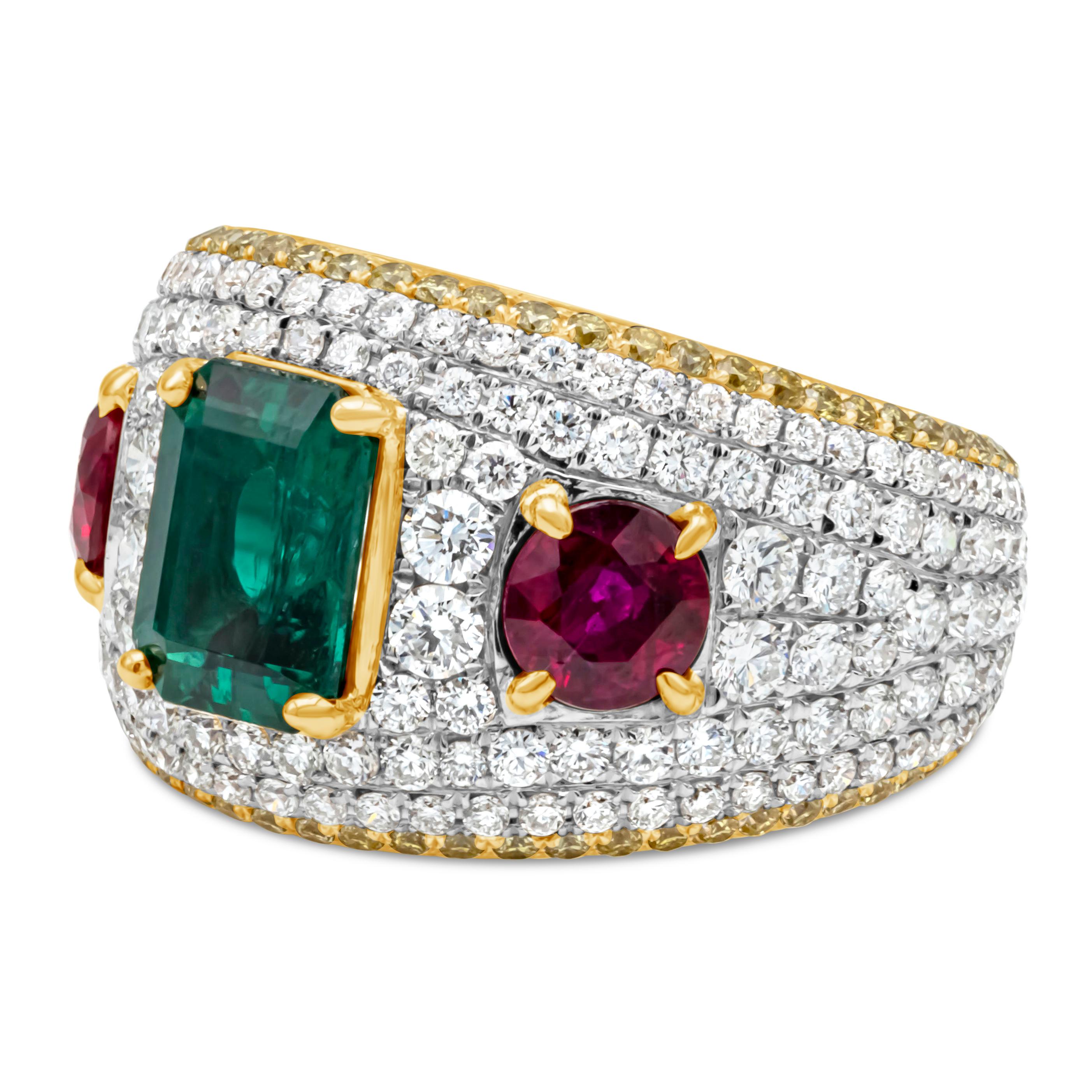 An exquisite fashion ring, showcasing a GIA certified 1.37 carats emerald cut green emerald and two round cut red rubies weighing 1.25 carats total, each set on a four prong setting. Accented by round brilliant cut white and yellow diamonds weighing