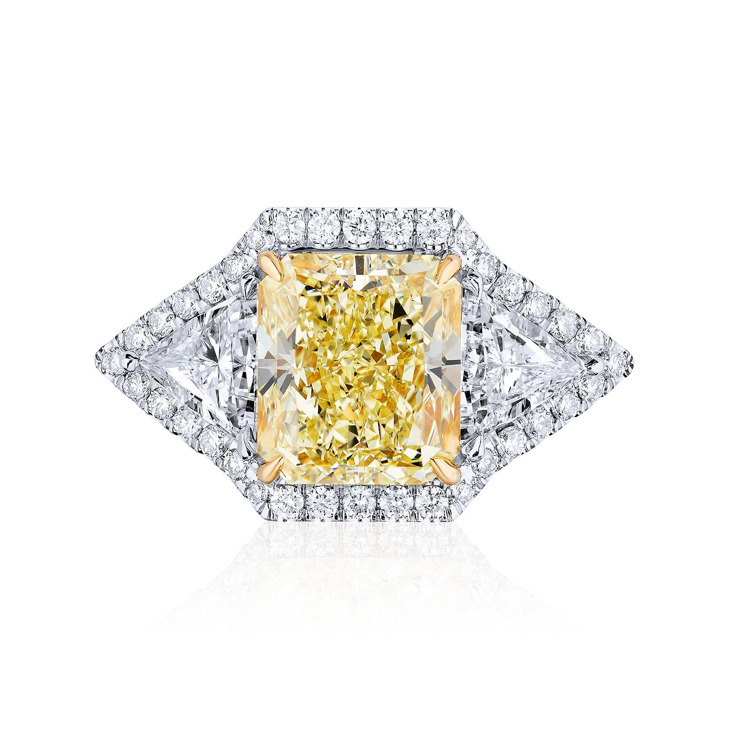 Centered upon a 5.02 Carat Radiant Cut Cut flanked by Triangle Shaped Diamonds and surrounded by Round Brilliant in a micro pave design.
6.96 Carats in Total.

Center stone weighing 5.02 Carats certified by GIA as Y-Z color and SI1