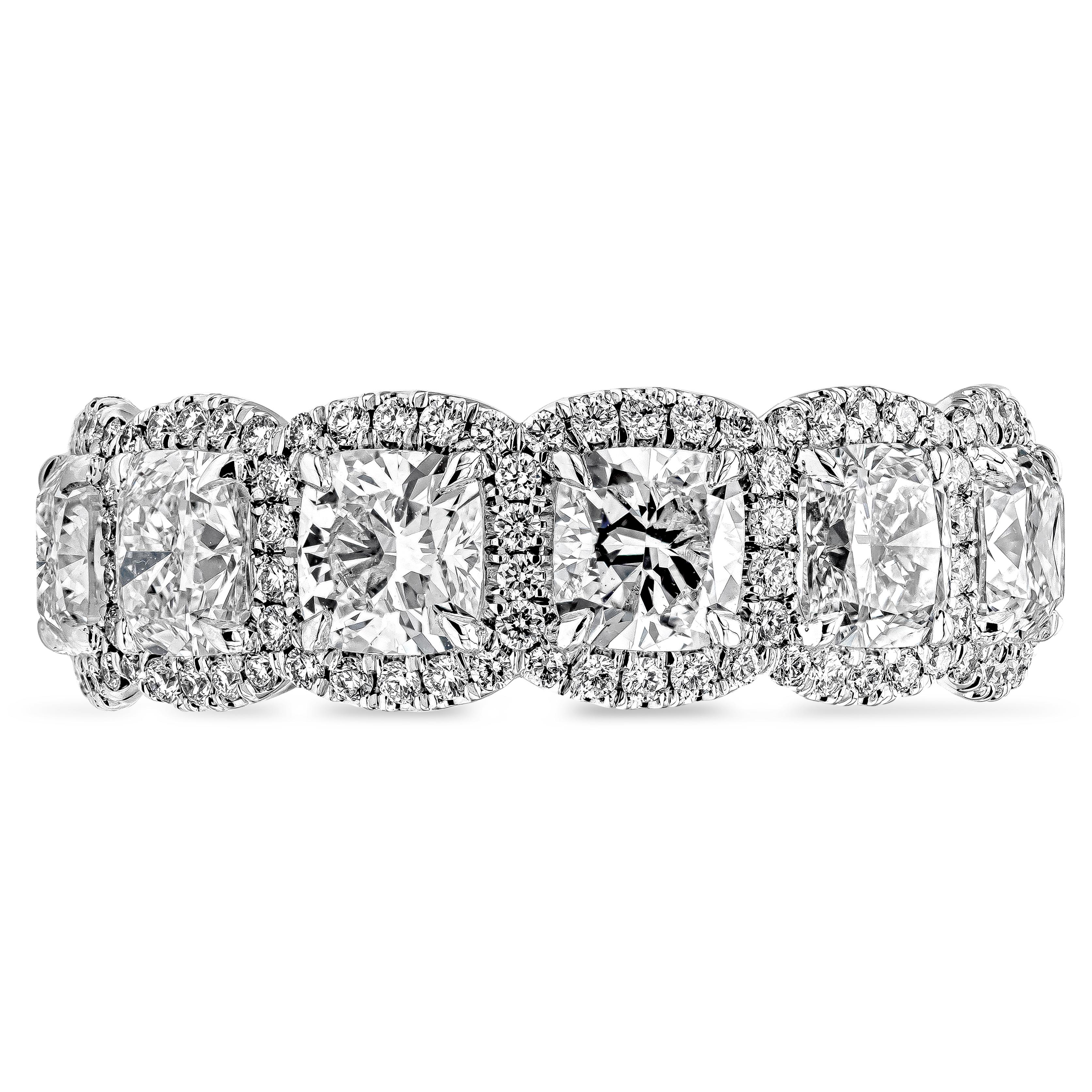 An intricately designed wedding band style showcasing a row of GIA Certified cushion cut diamonds, E-F Color, and VS-VVS in Clarity. Each cushion cut diamond is surrounded by a single row of brilliant round diamonds weighing 0.70 carats total, E-F