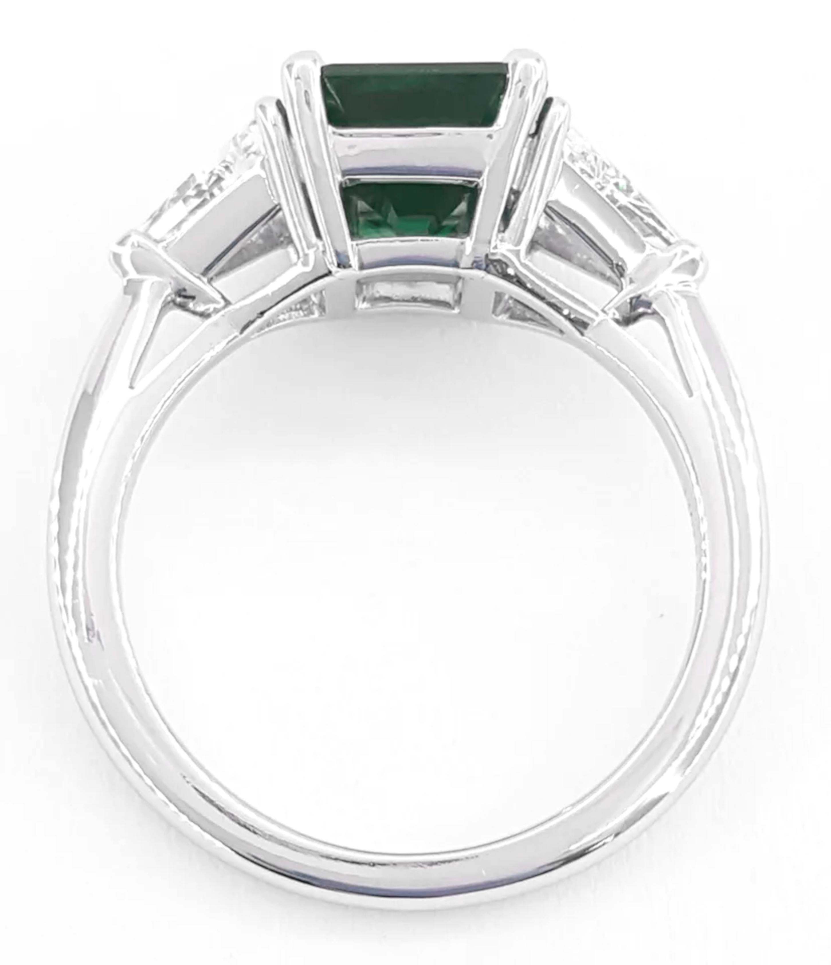 A breathtaking masterpiece: a 4.98 carat natural emerald, certified by GIA  radiating with unparalleled beauty. 
This exquisite gemstone is elegantly set in a solid platinum ring, flanked by two stunning trillion-cut diamonds, each certified by GIA