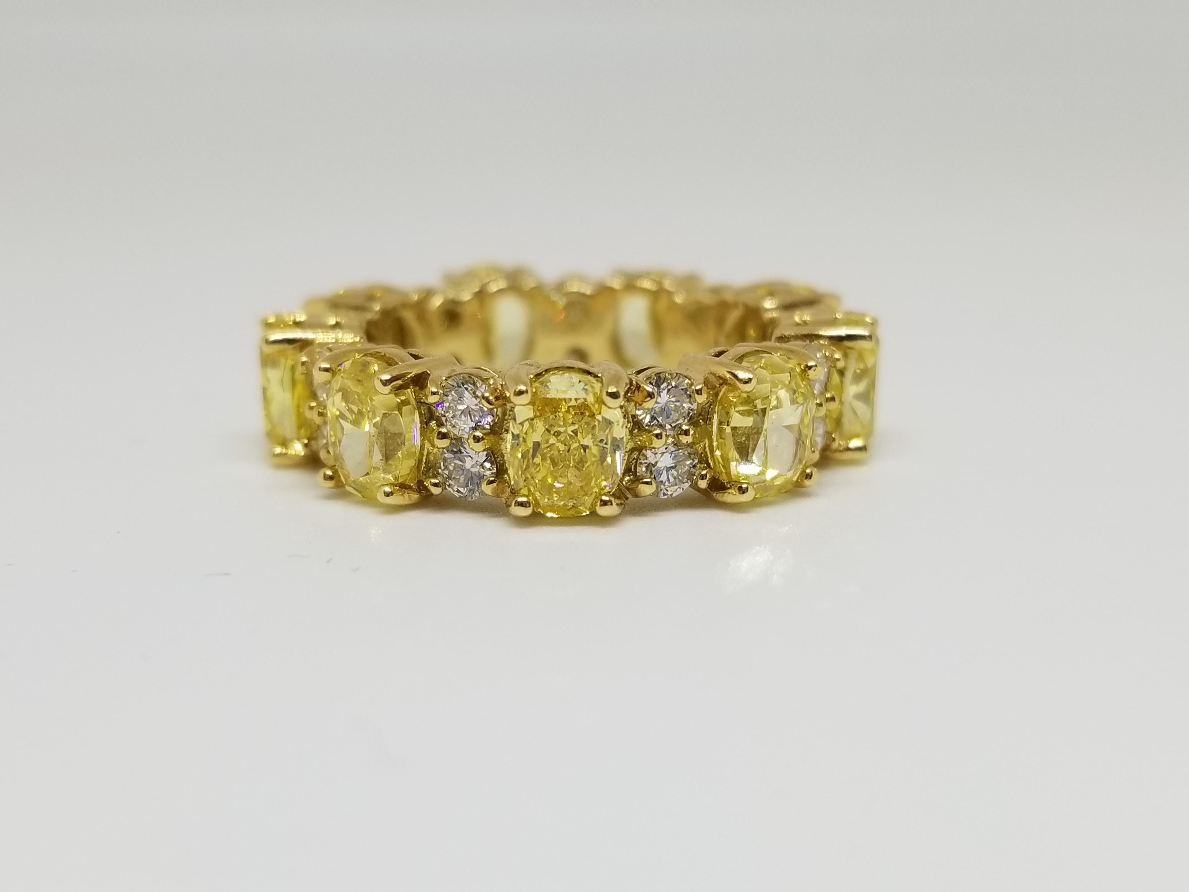 9 Natural Fancy Vivid Yellow oval diamond weighing 4.98 total carats all GIA certified. Paved with white diamonds in the  setting. Its transparency and luster are excellent. set on 18K yellow gold, this ring is the ultimate gift for anniversaries,