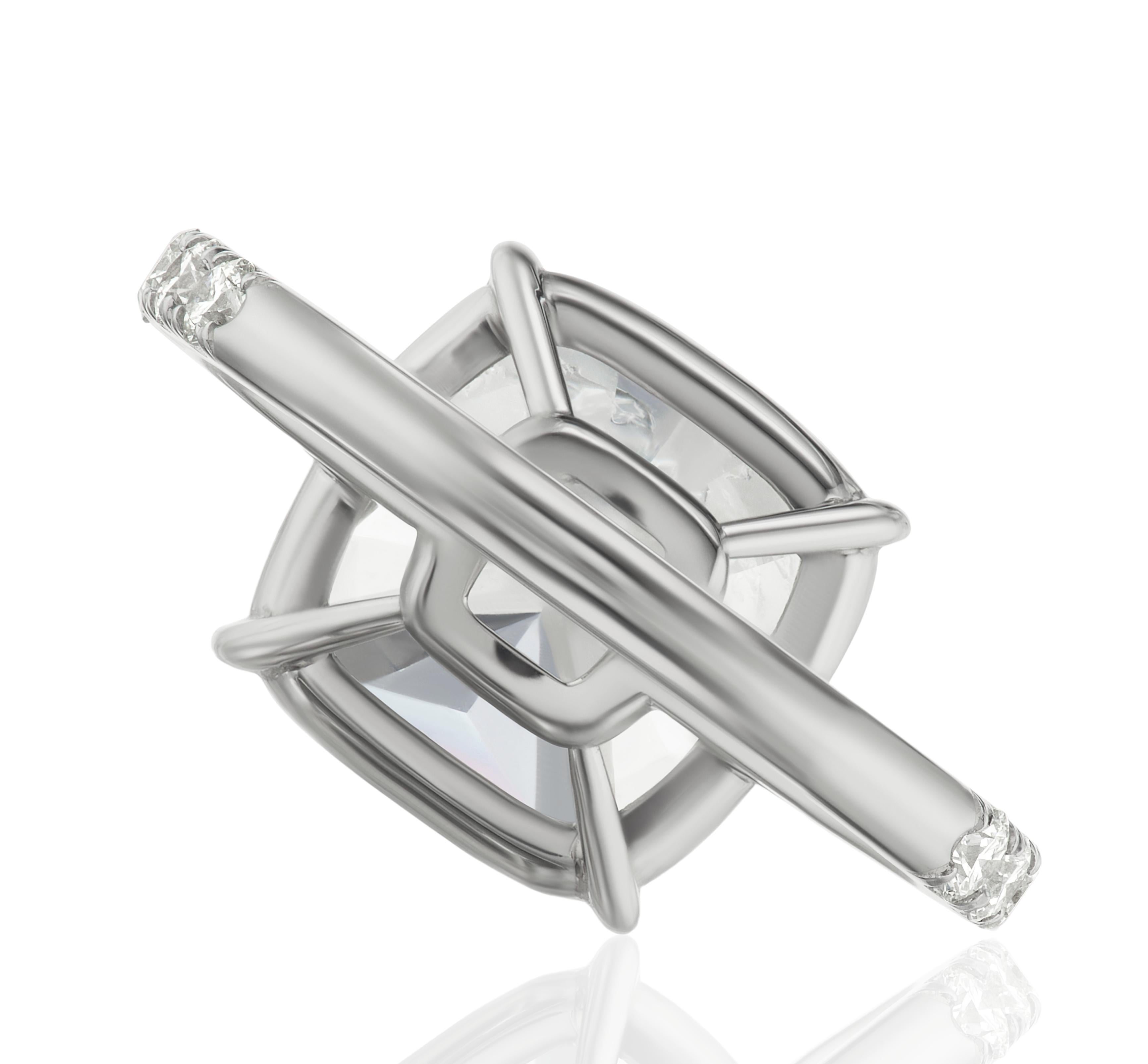 Cette bague exquise, certifiée GIA, est ornée d'un magnifique diamant de 5 carats de taille coussin, serti dans un anneau en or blanc 18 carats orné de diamants pavés. 

Le diamant est de couleur F, presque incolore et réputé pour sa brillance