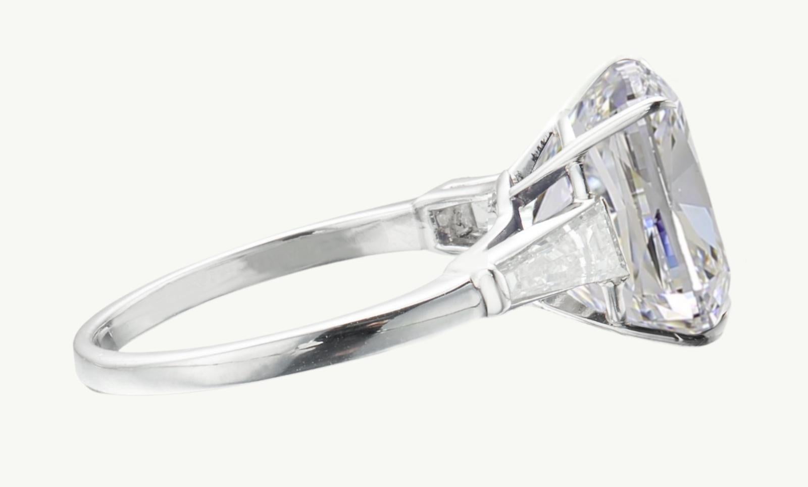 Voici une extraordinaire bague en platine à l'allure intemporelle, ornée d'un magnifique diamant coussin brillant certifié GIA. Le diamant central, d'une taille remarquable de 5 carats, présente des caractéristiques impeccables : Couleur E, pureté