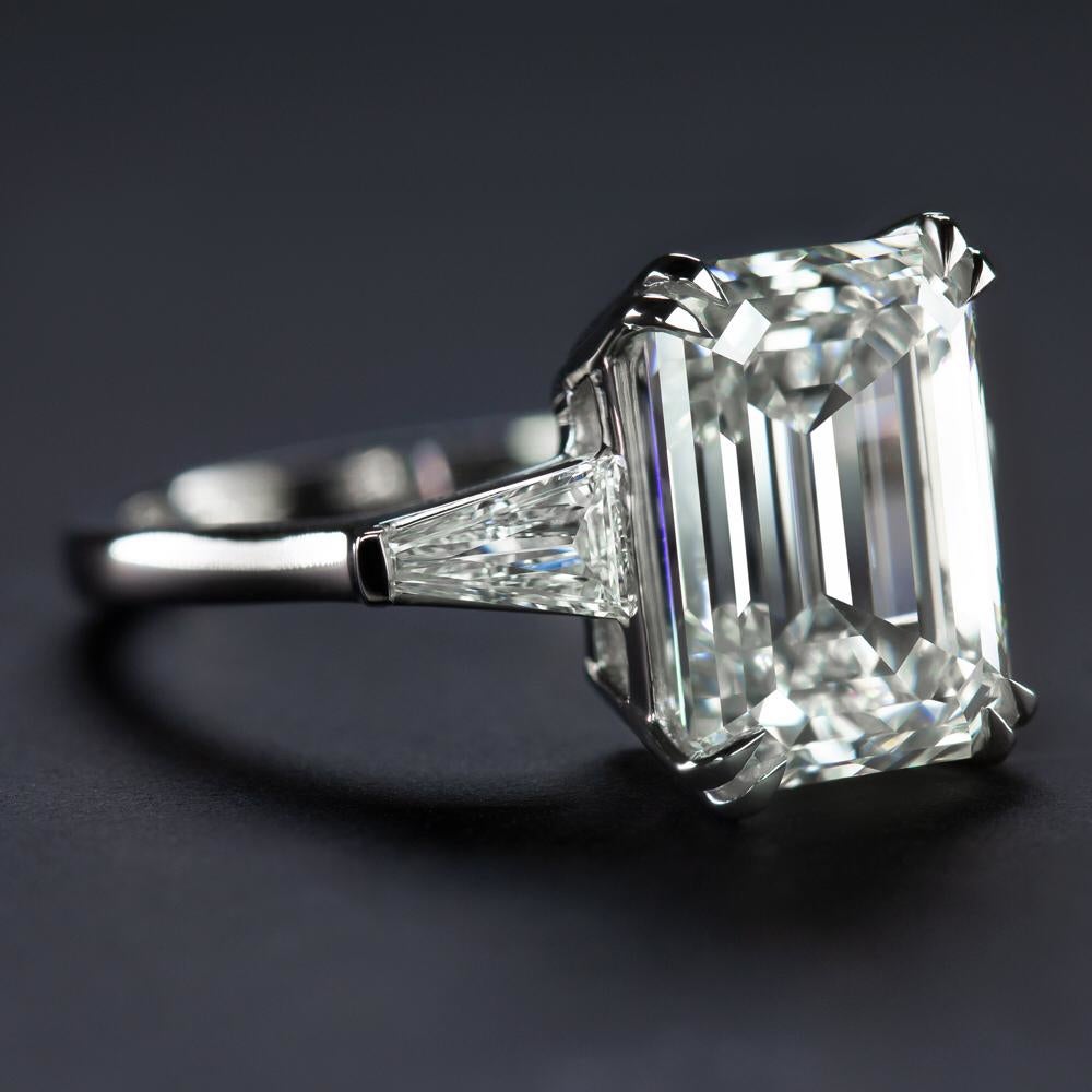 This remarkable GIA certified ring showcases a 5 carat emerald cut diamond as its centerpiece, exuding elegance and refinement. 
Mounted in platinum, the central diamond is flanked by two tapered baguette diamonds, creating a graceful silhouette
