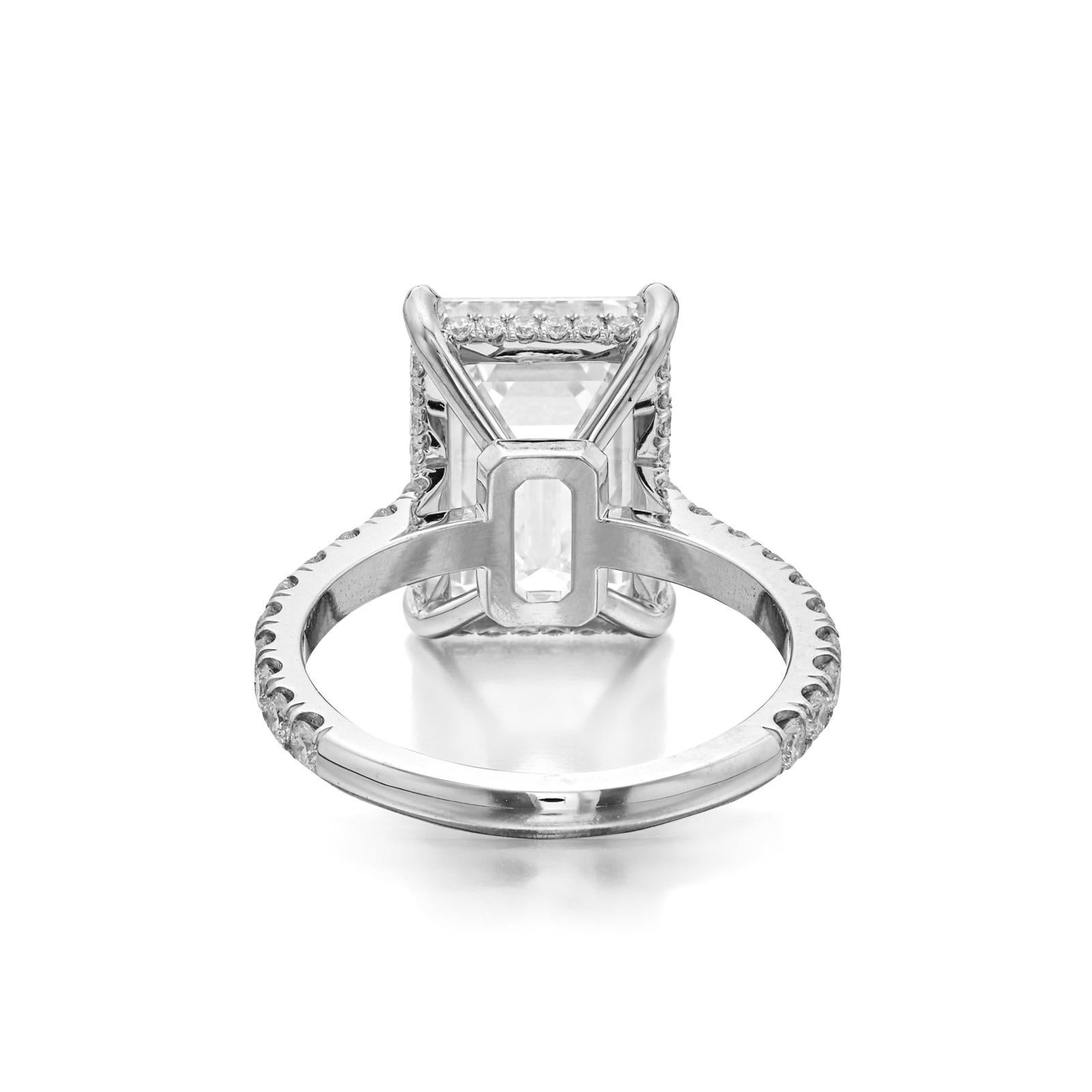 An exquisite Ring, featuring a remarkable total weight of 5 carats. This exquisite piece showcases a captivating center diamond, a Natural Emerald Cut weighing 5 carats, graded f in color and vs1 in clarity. The diamond's impeccable specifications